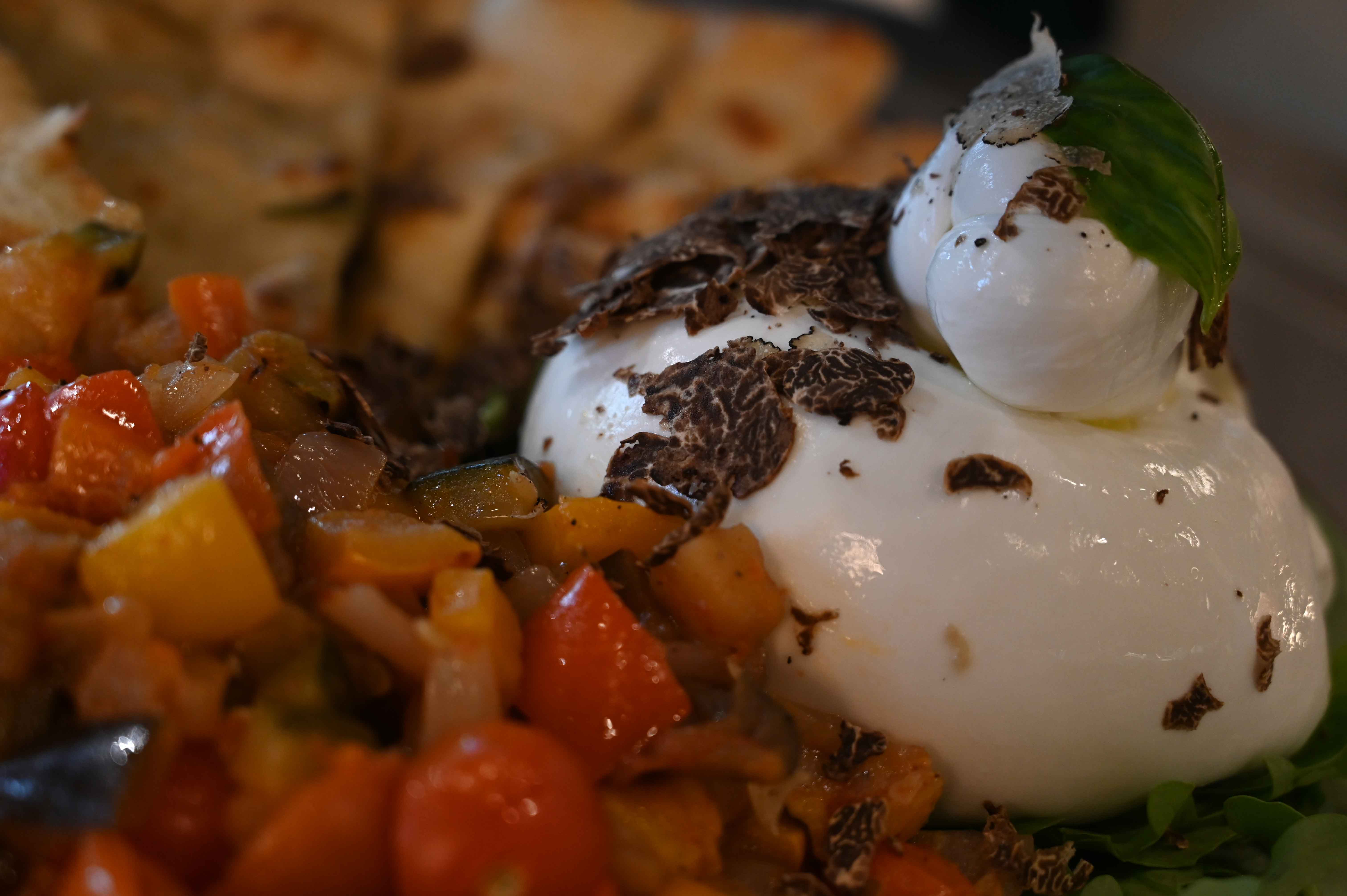 Fresh cheese topped with truffle slices and basil
