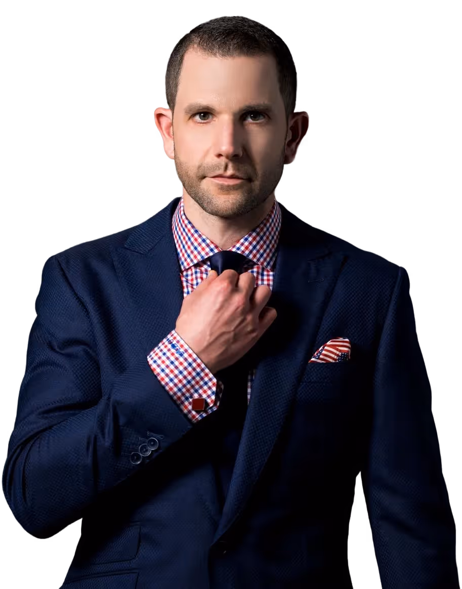Man in a navy blue suit adjusting his dark tie, wearing a red and white checkered shirt and a red-striped pocket square, against a black background.