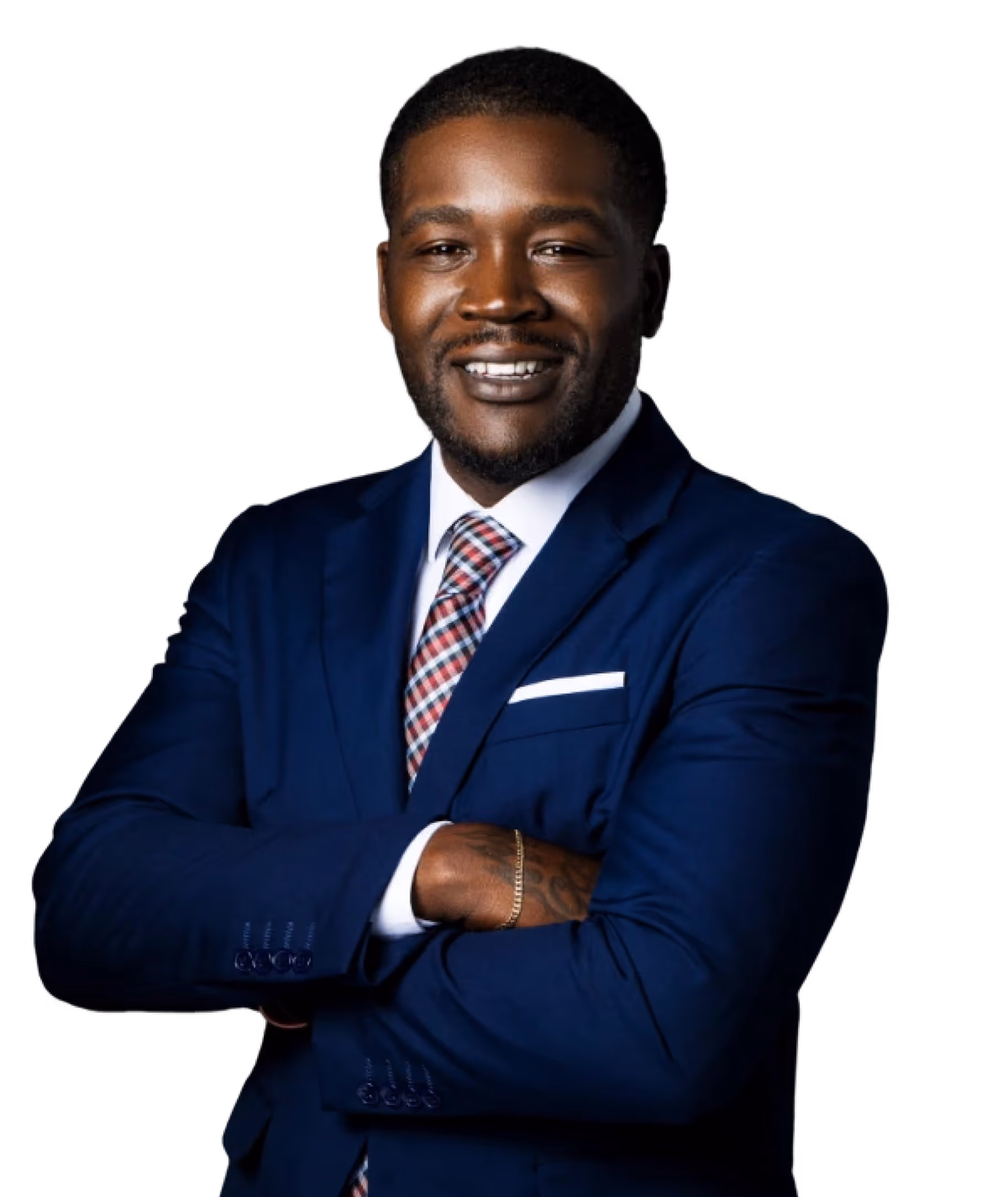 Smiling man in a blue suit with a white shirt and checkered tie standing with arms crossed against a black background.