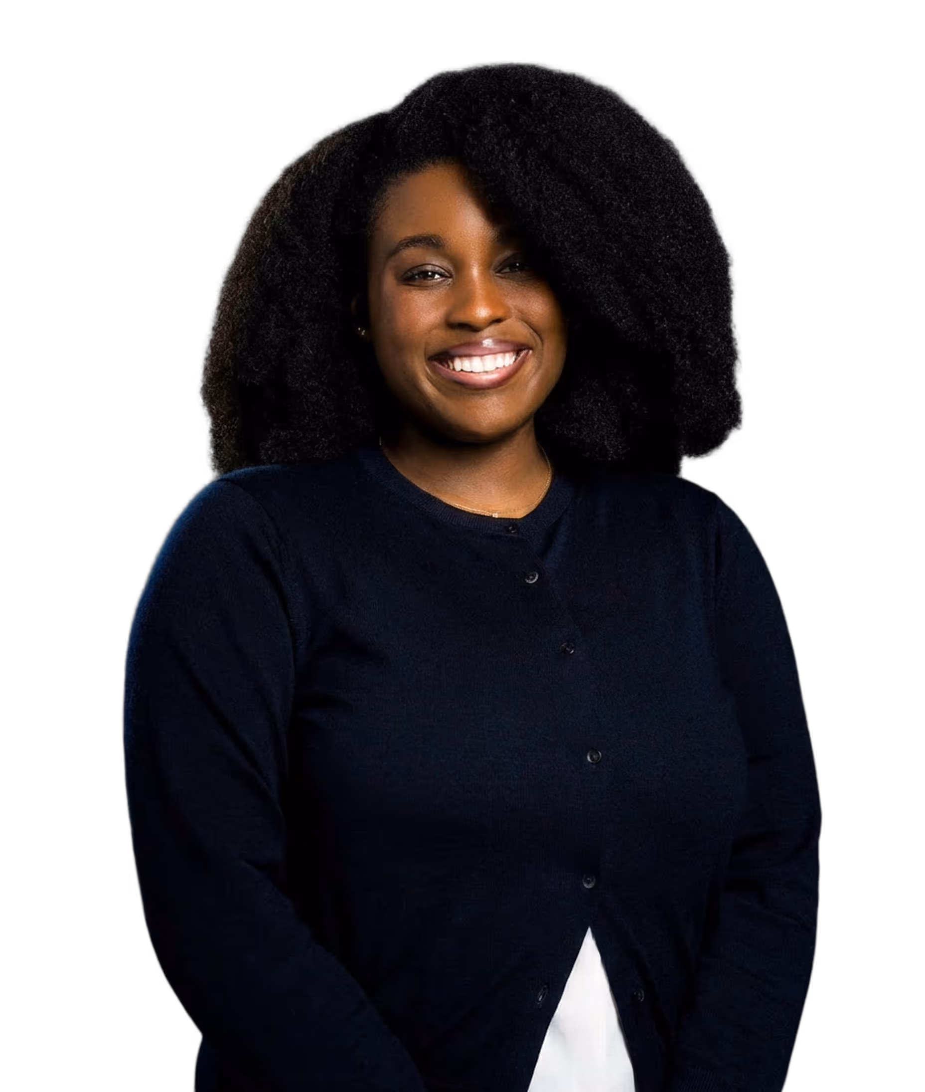 Smiling woman with voluminous curly hair wearing a dark navy cardigan over a white top.