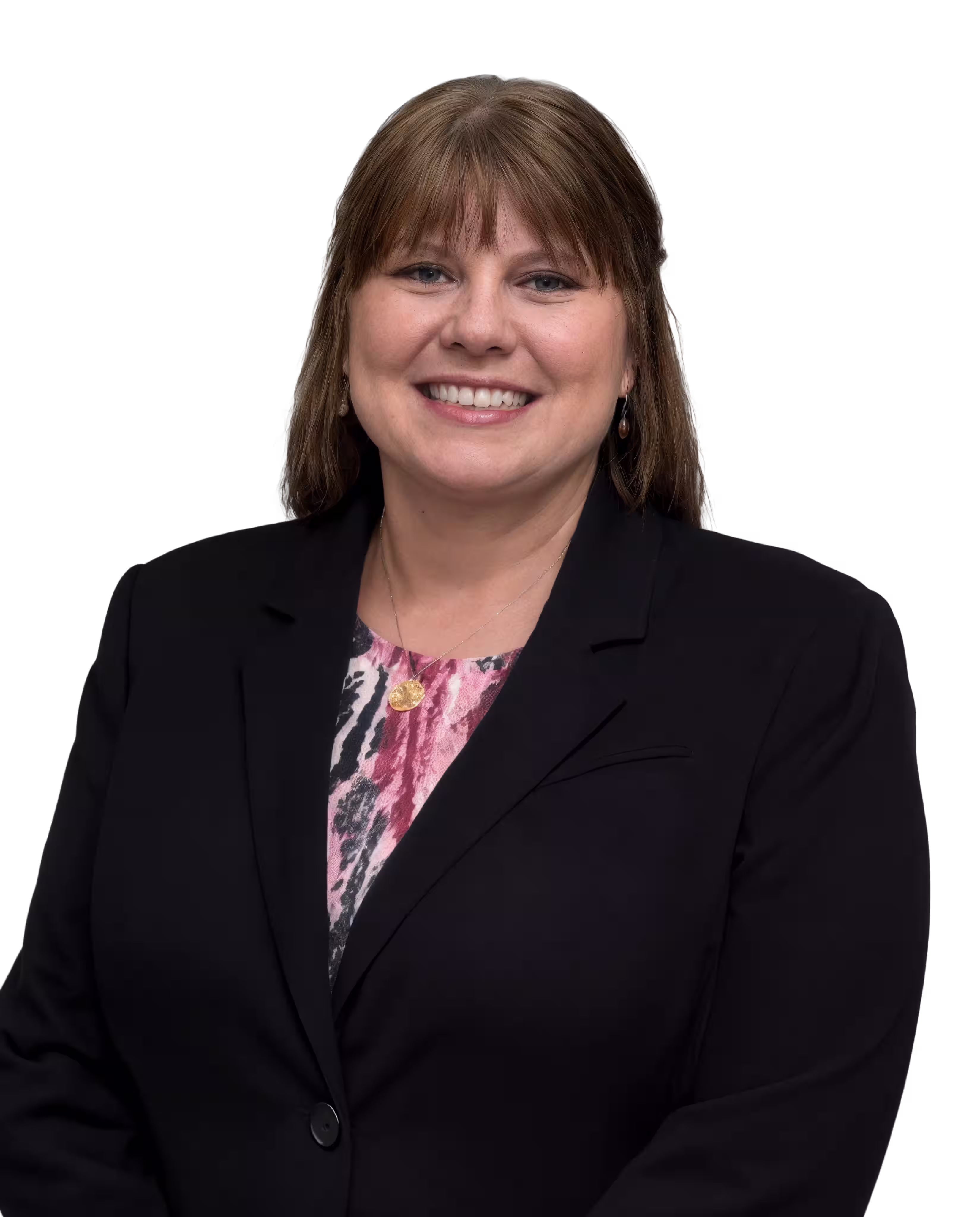 Smiling woman with straight brown hair wearing a black blazer and pink patterned blouse.