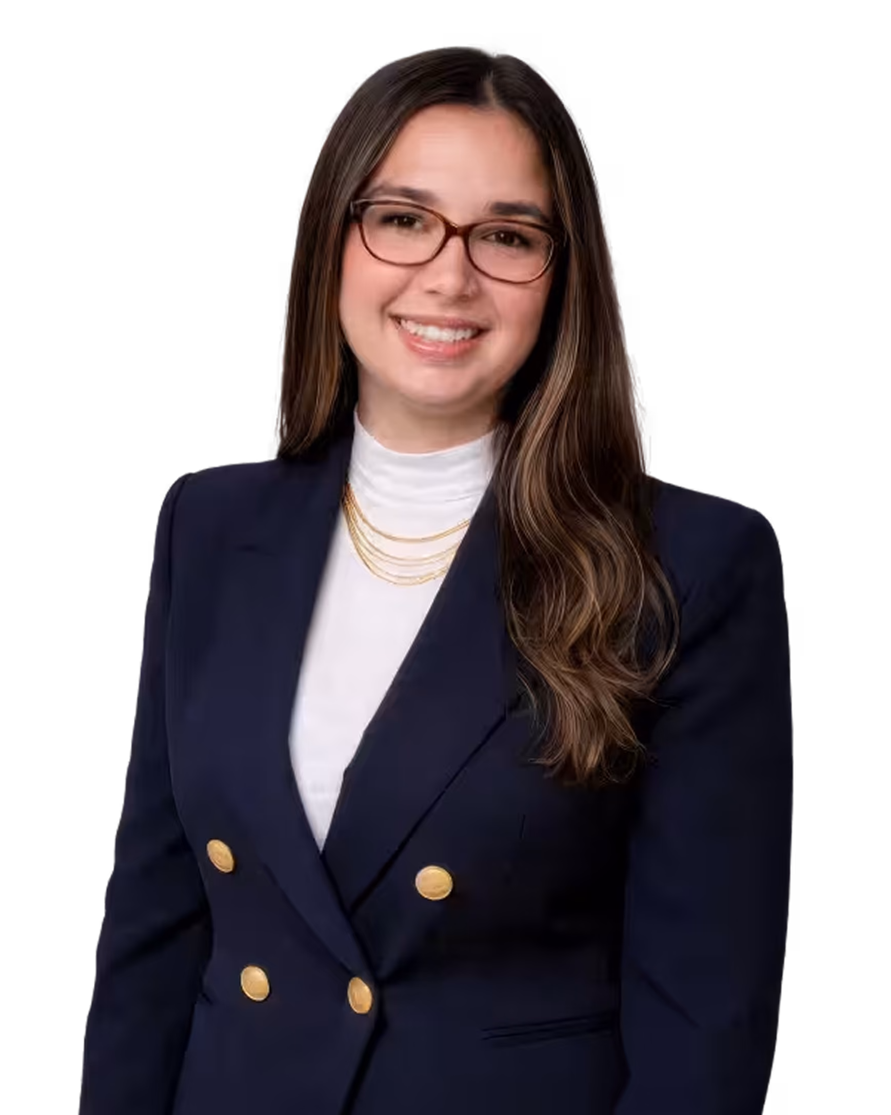 Smiling woman with long brown hair, wearing glasses, a navy blazer with gold buttons, a white high-neck top, and layered gold necklaces.