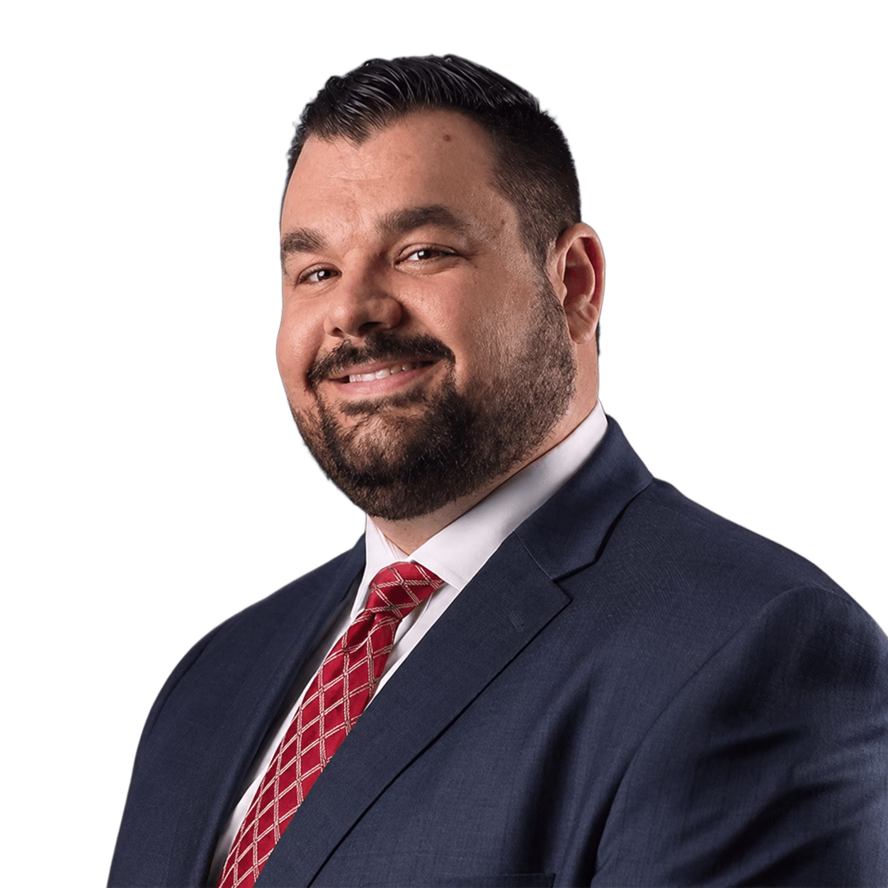 Smiling man with dark hair and beard wearing navy suit, white shirt, and red patterned tie.