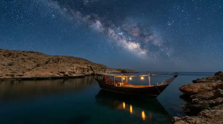 Boat moored beside a Daymaniyat island under the stars, Oman