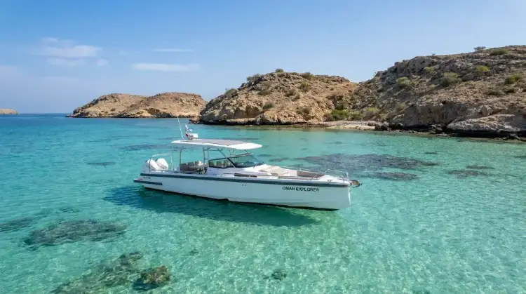 Private tour boat moored in a turquoise Daymaniyat Islands bay near Muscat