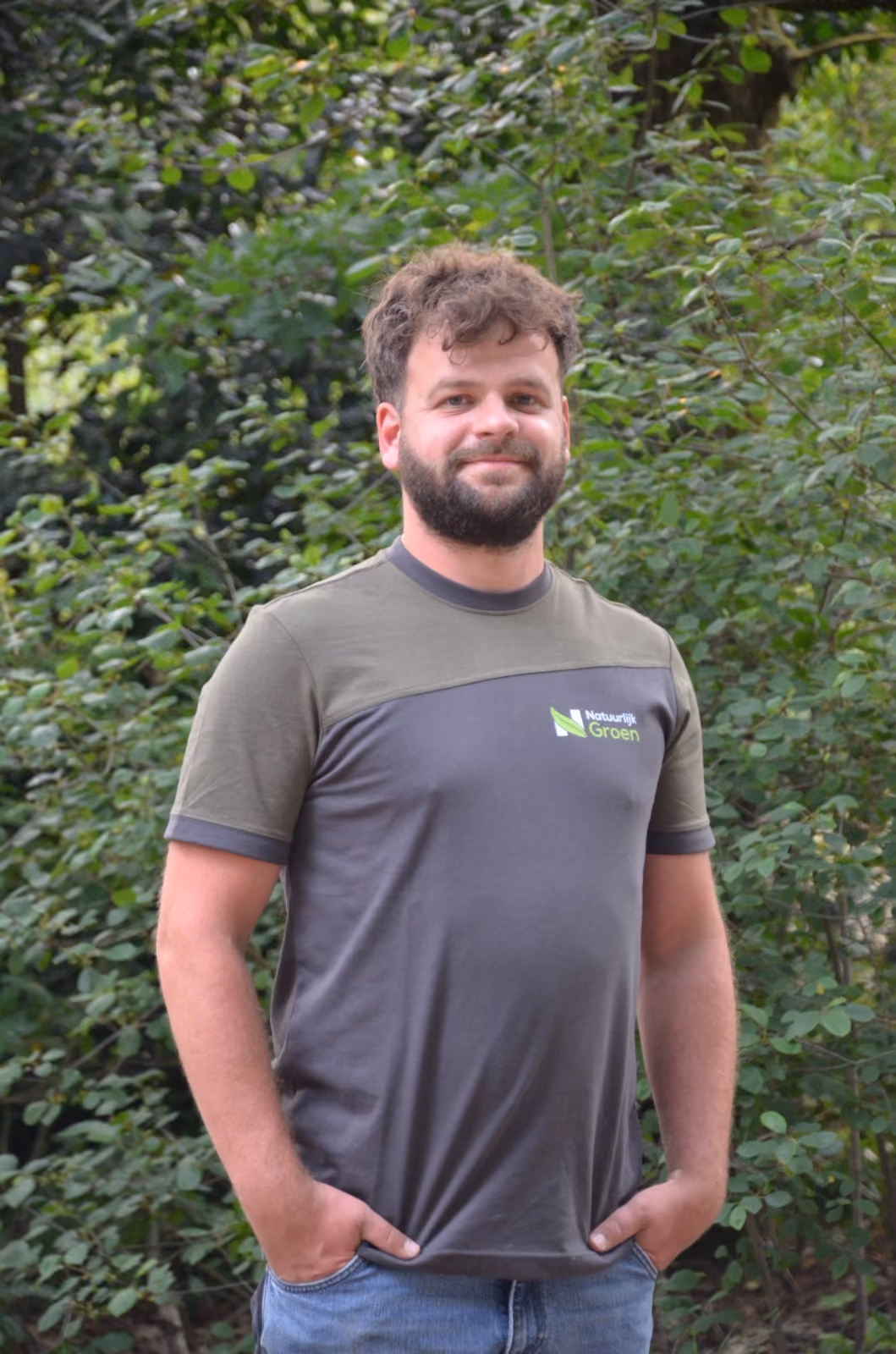 Medewerker van Natuurlijk Groen in bedrijfsshirt voor een groene haag.