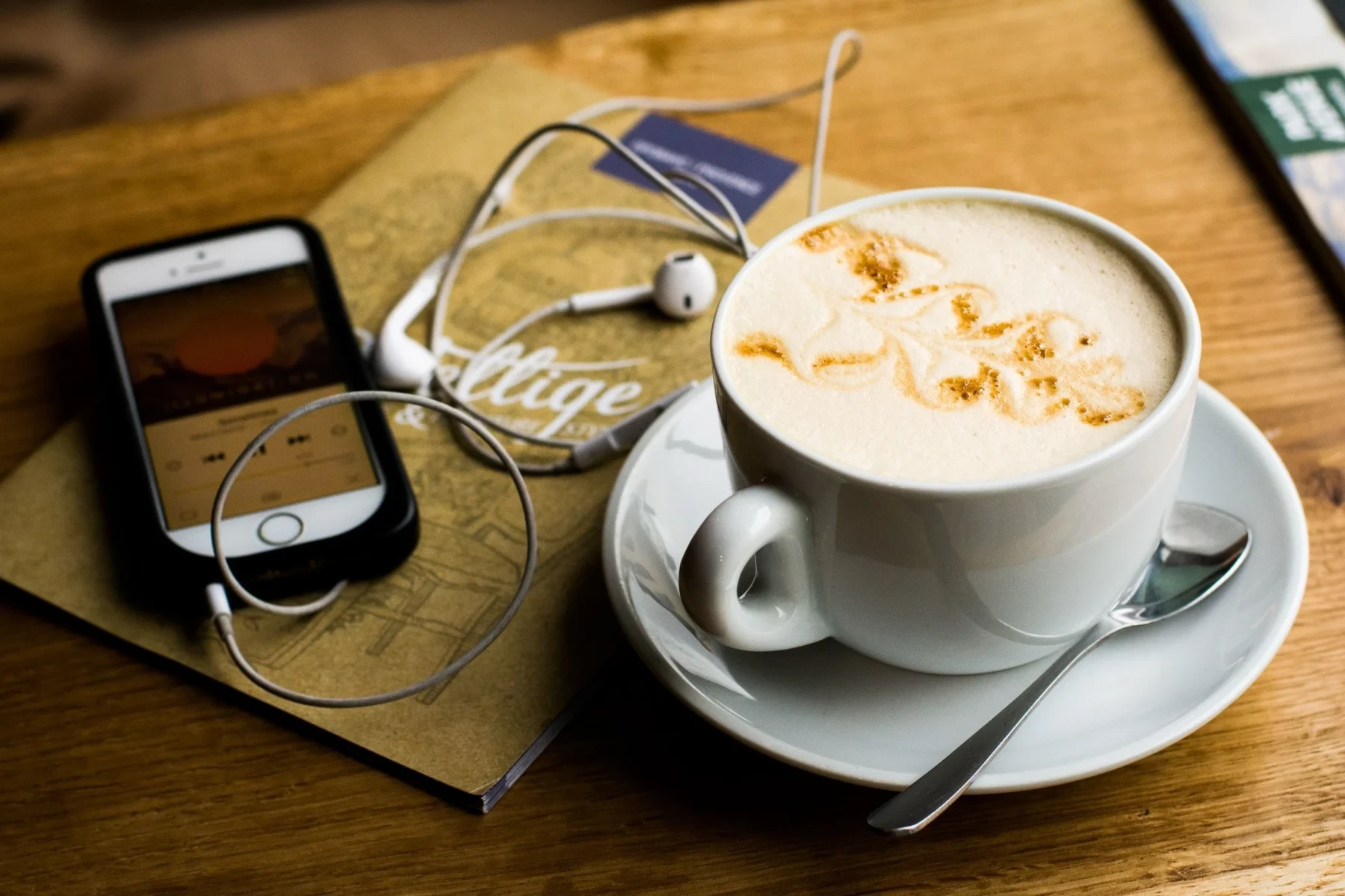 Coffee, iphone and headphones on a table