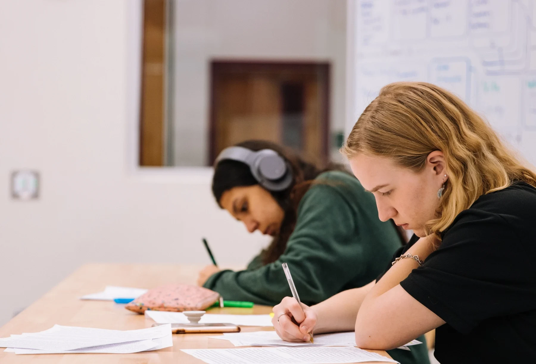 Two students writing in classroom