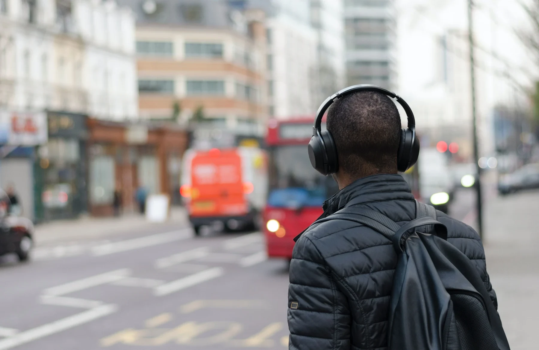 A man with headphones lookin at the street