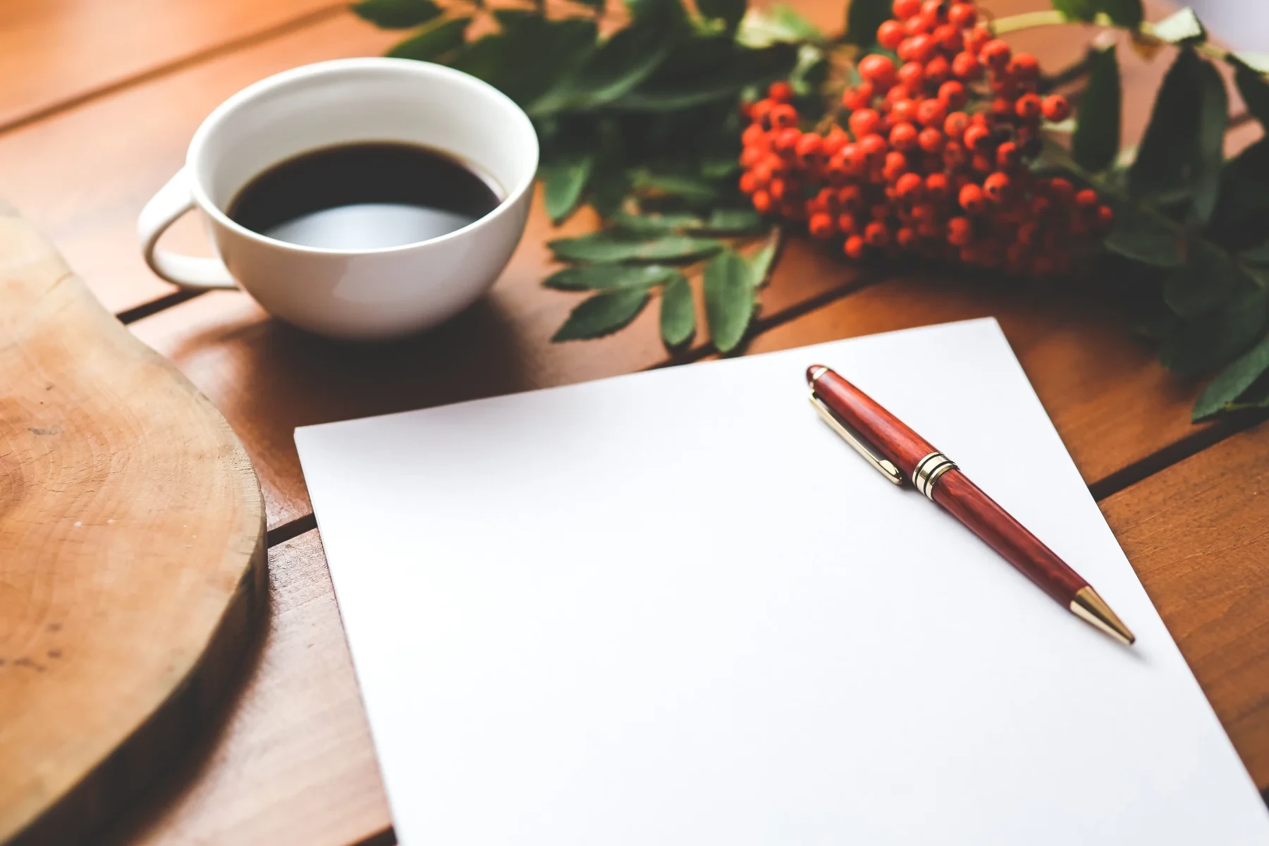 Blank paper with pen and coffee on a table