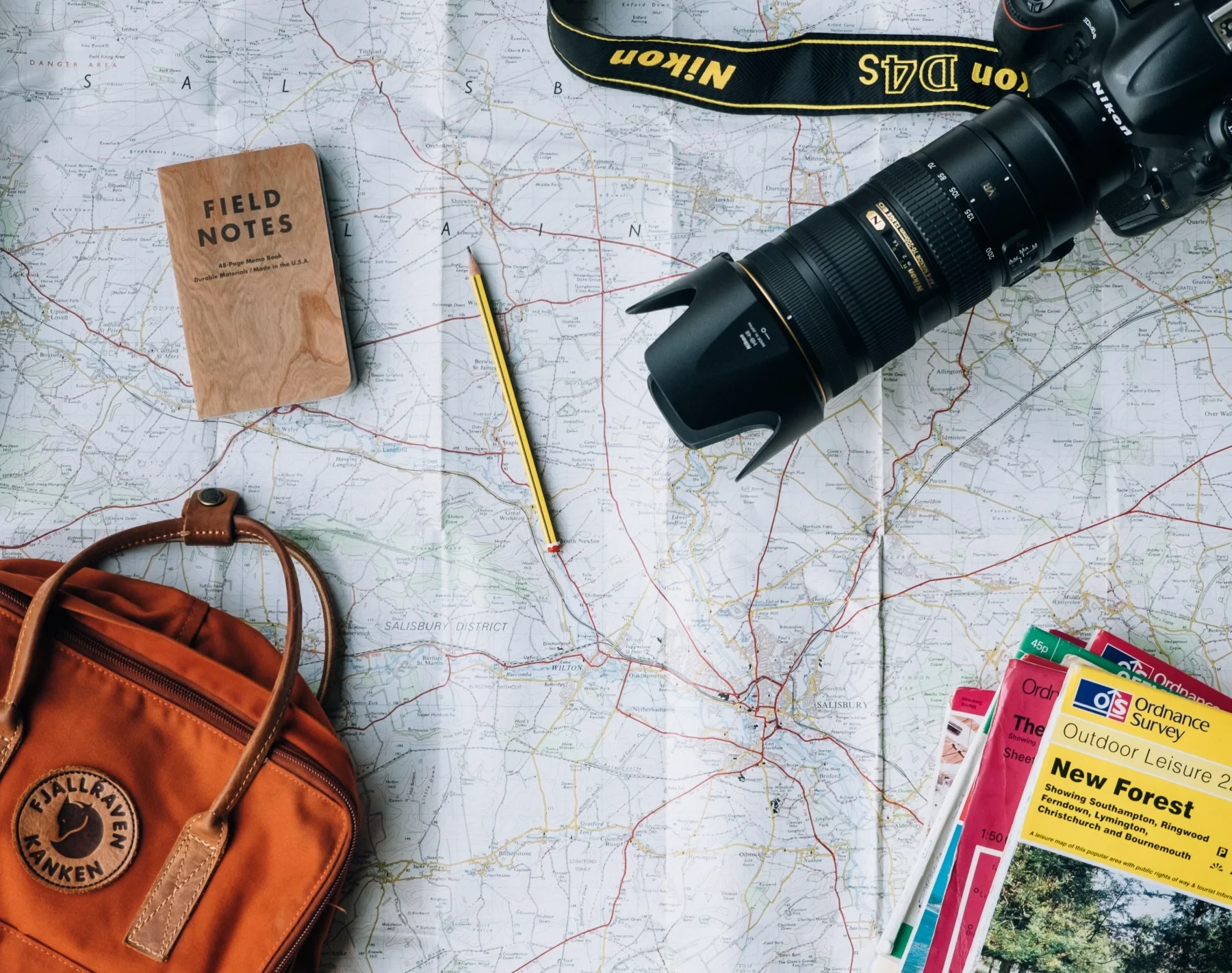 A map, pencil, notebook and a camera