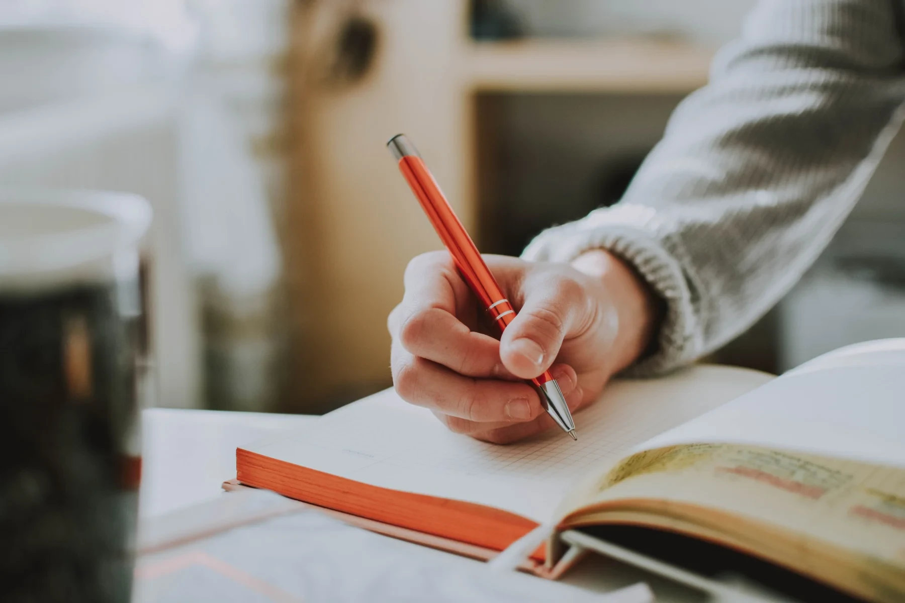 Hand holding a pen on a notebook