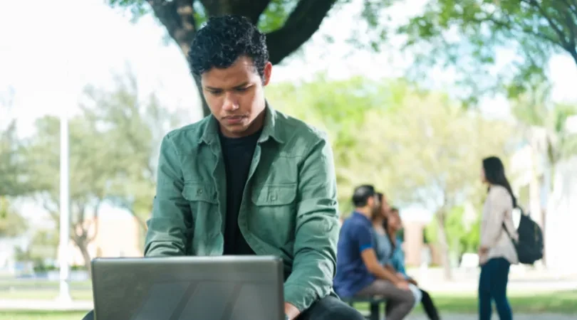 A student working on the laptop outside