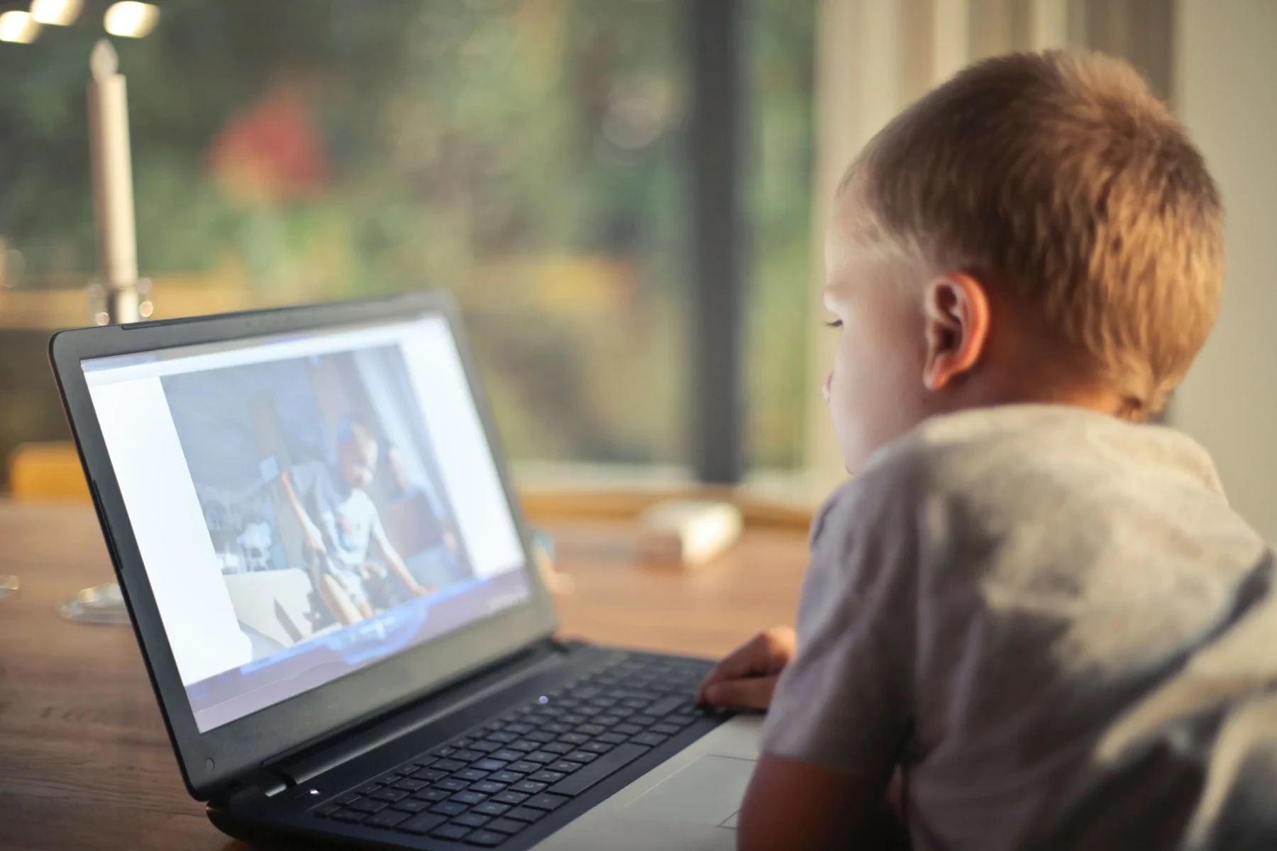 A boy watching videos on a laptop