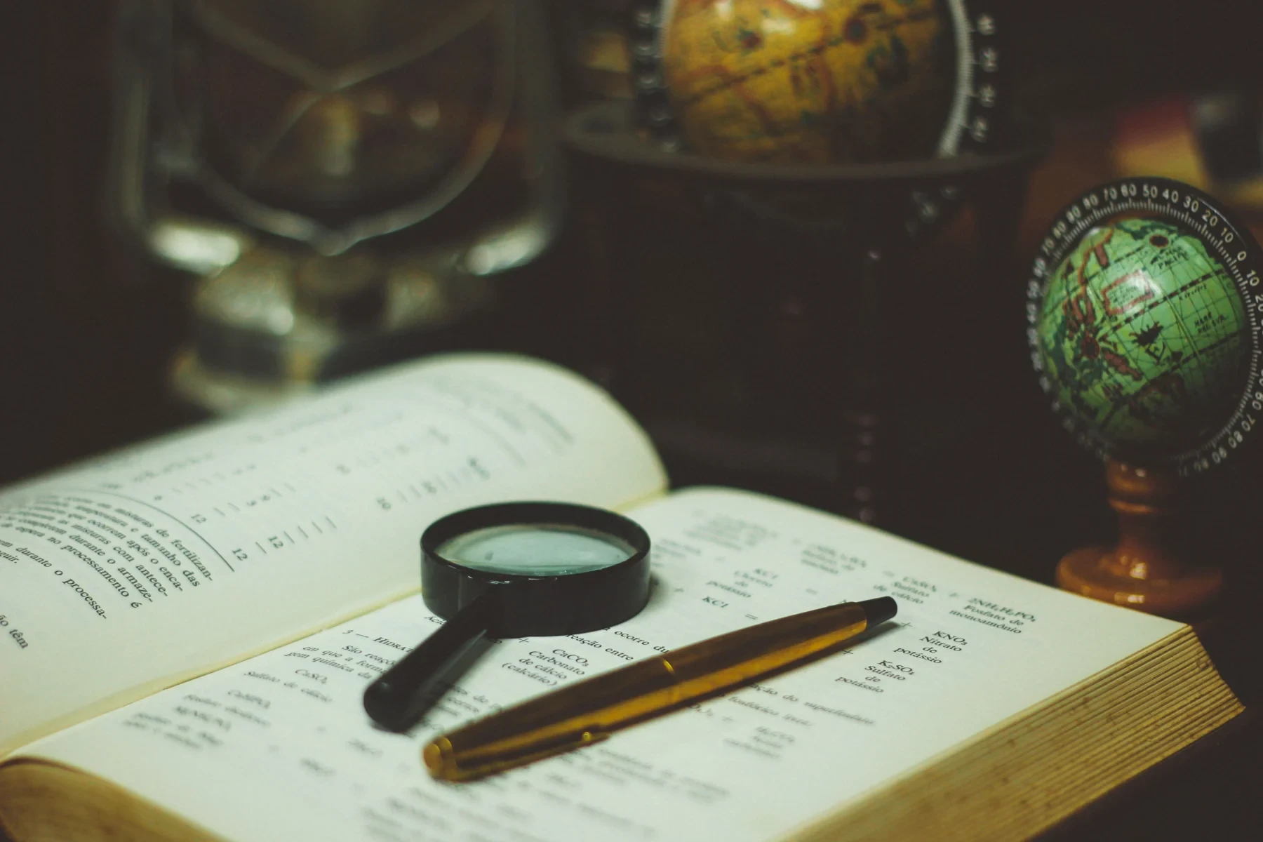 Magnifying glass and a pen on a book