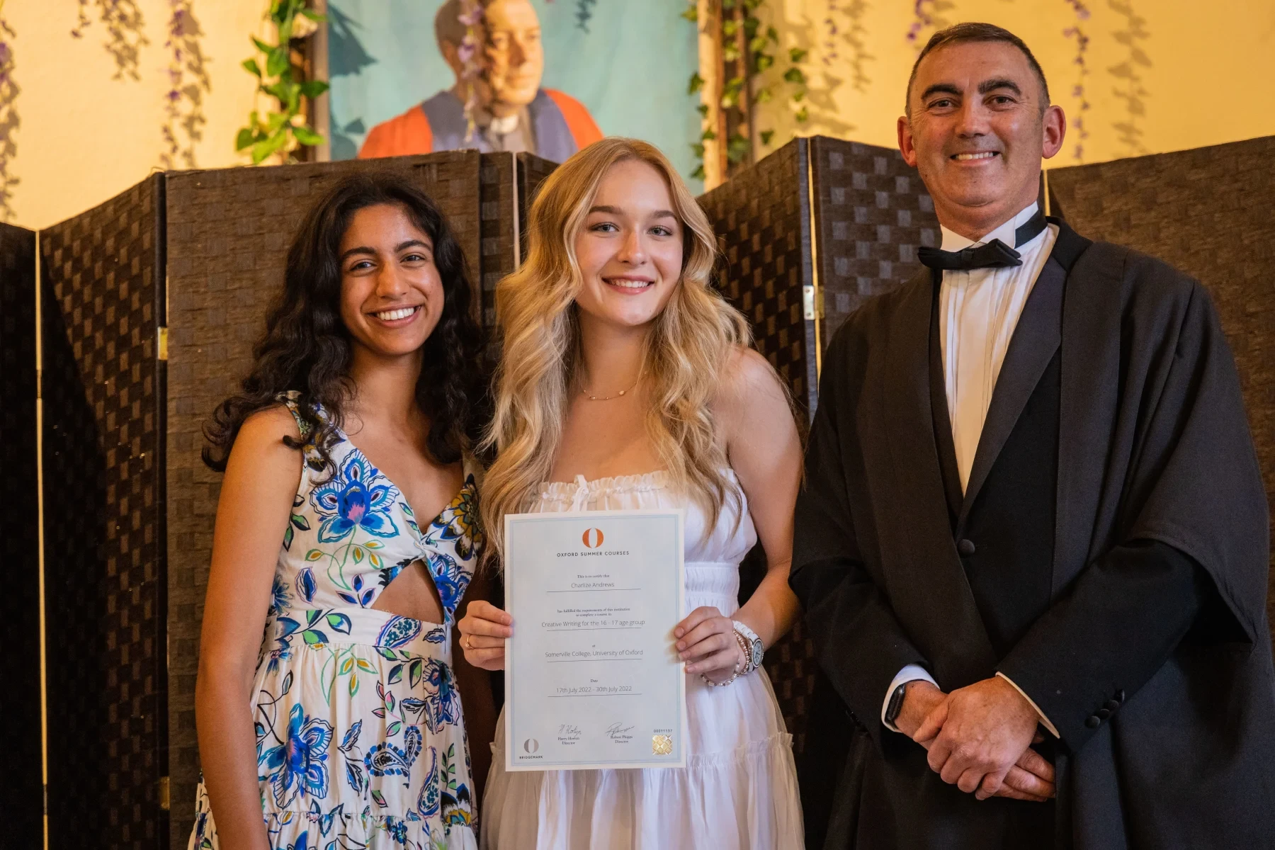 Students posing for a picture with a diploma