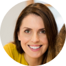 Smiling woman with brown hair wearing a yellow top.