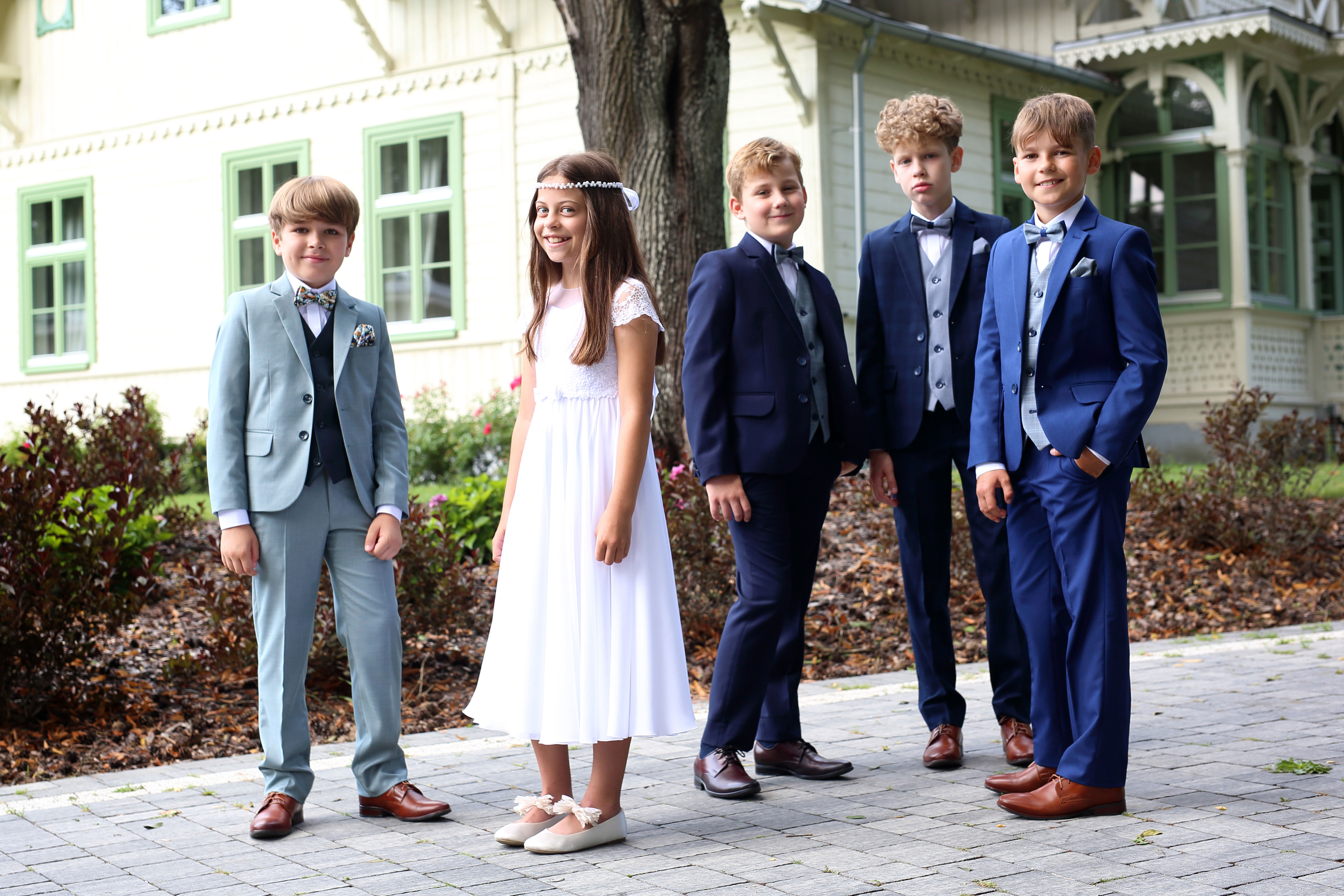 Eine Gruppe von Kindern in Anzügen und Kleidern