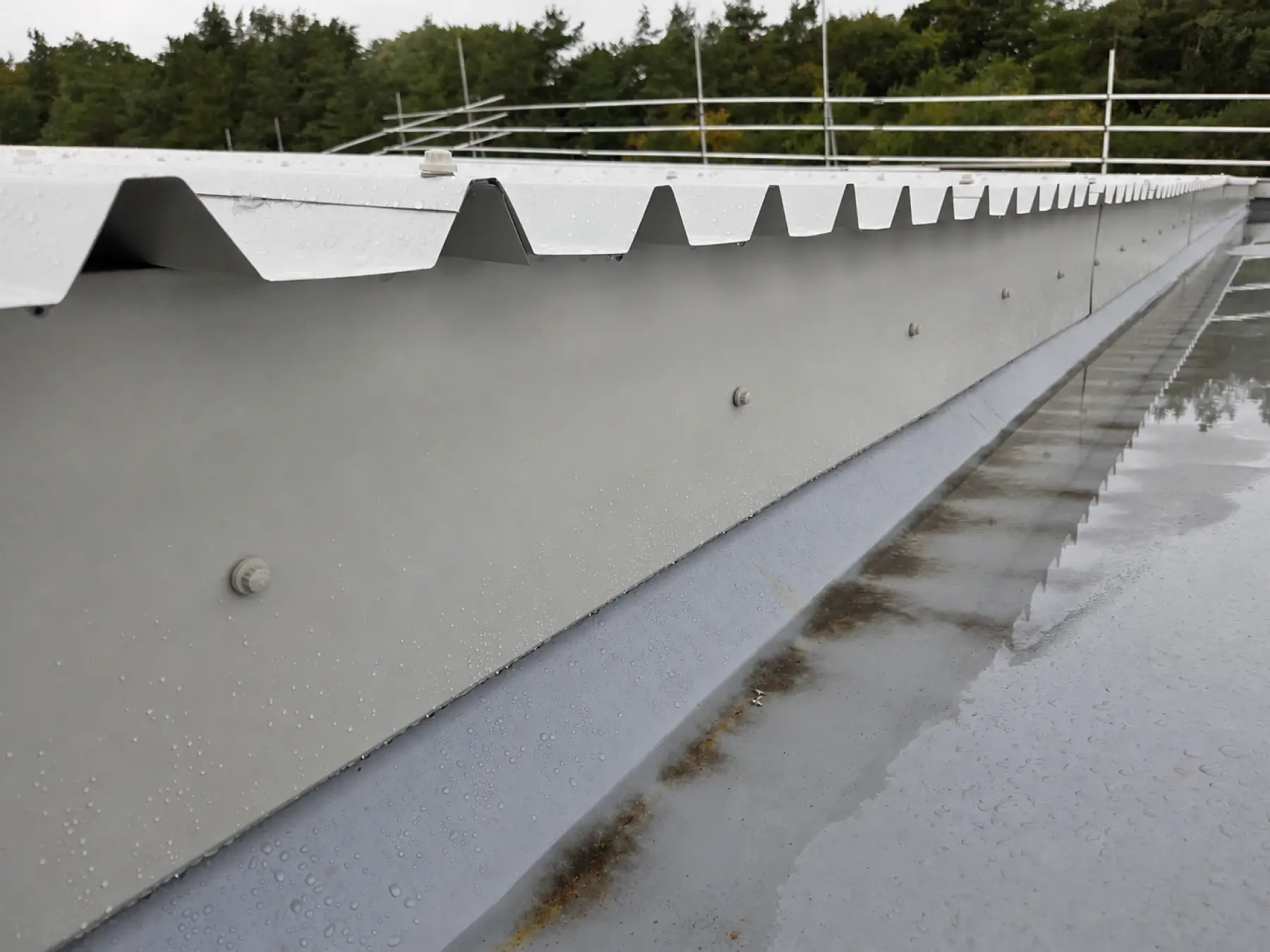 Profiled metal sheet ends and flashing above a wet membrane-lined gutter on the Phoenix Medical roof, East Kilbride