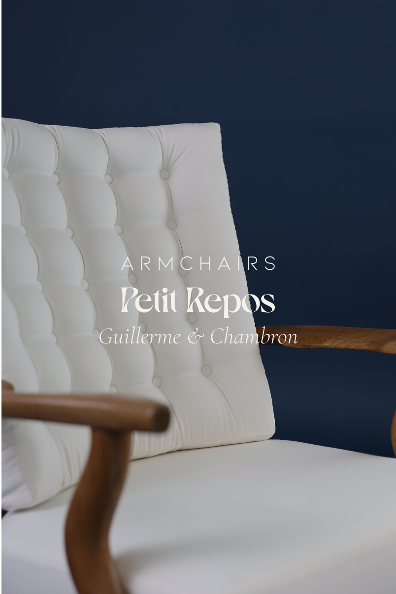 Petit Repos armchair by Guillerme et Chambron - full front view featuring white fabric upholstery and solid oak frame on a dark background