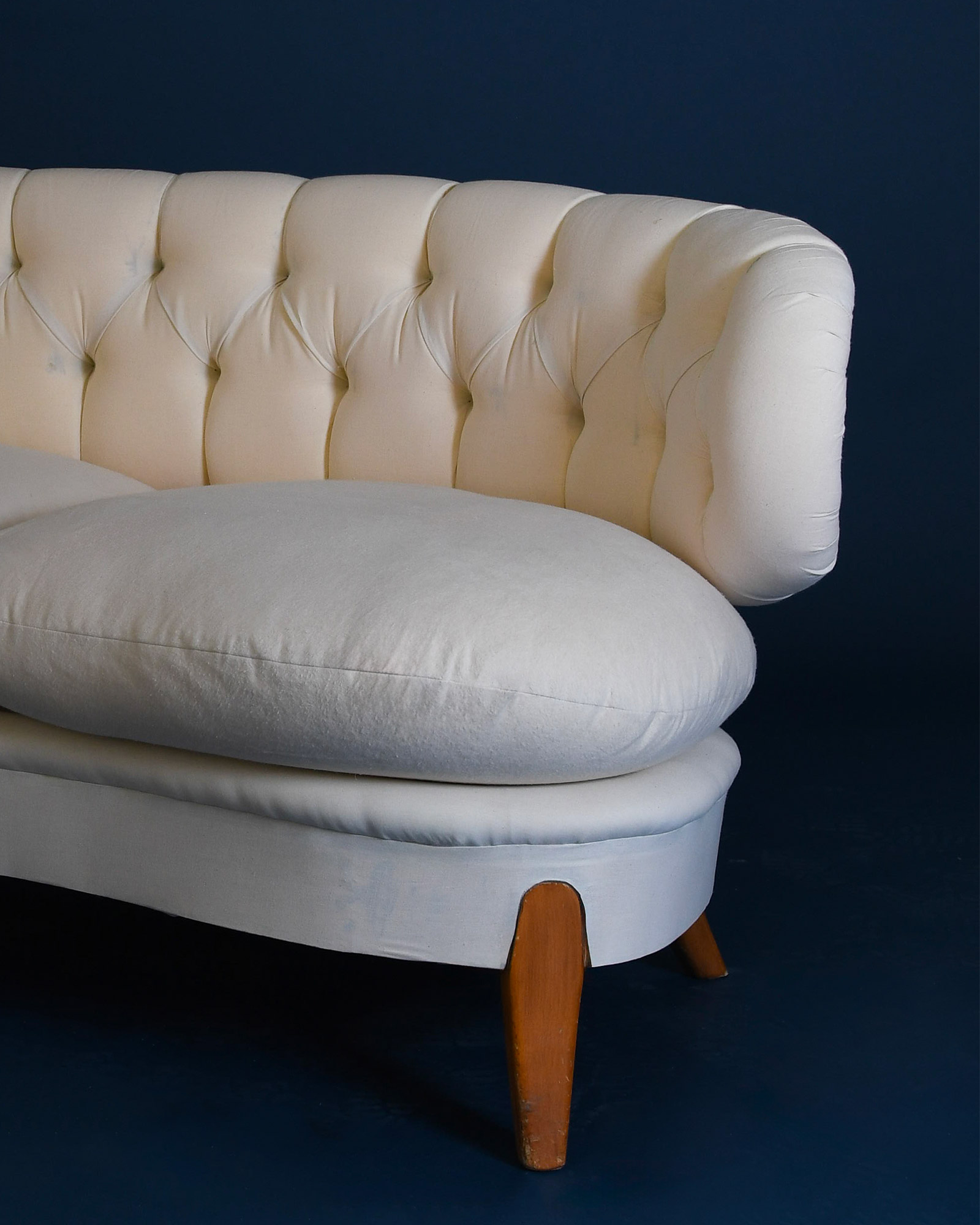 A close-up view of the central section of the Otto Schulz Boet sofa, highlighting the precise button tufting, fabric texture, and clean stitching details.