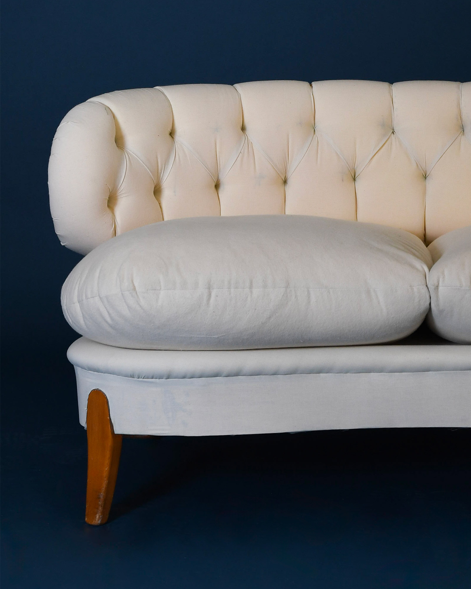 A detailed profile view of the Otto Schulz Boet sofa, emphasizing the slope of the backrest, the depth of the seat, and the visible dark wood base with its conical legs.