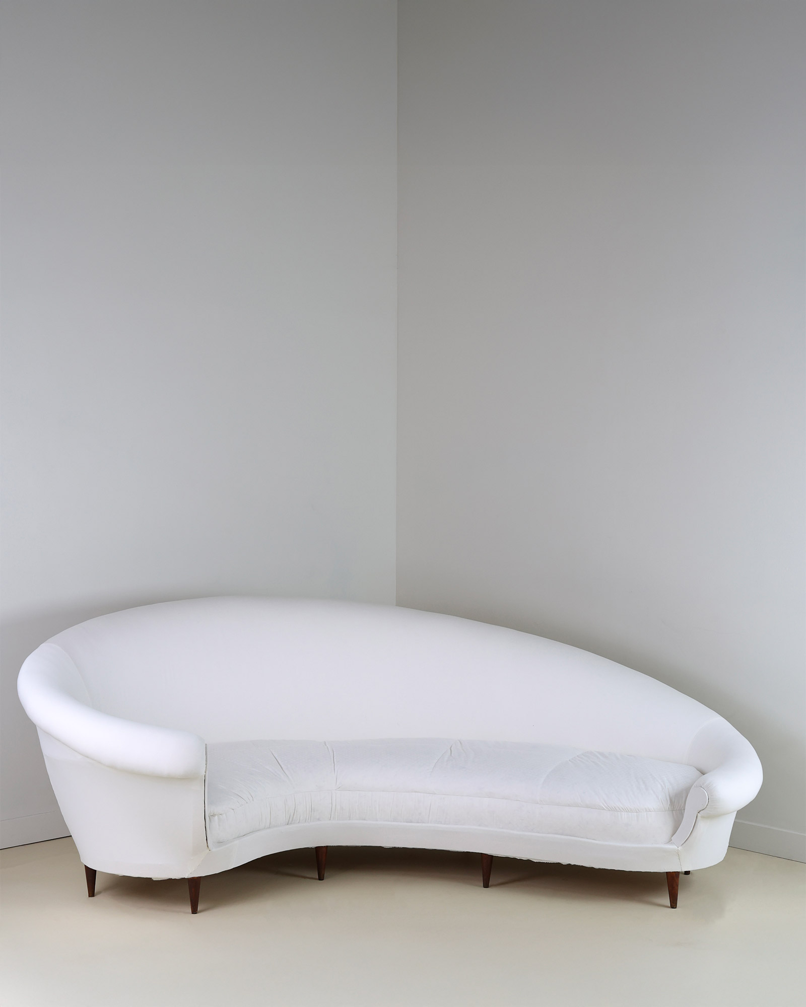Munari curved sofa by Federico Munari - full front view showing its organic serpentine shape and cream upholstery