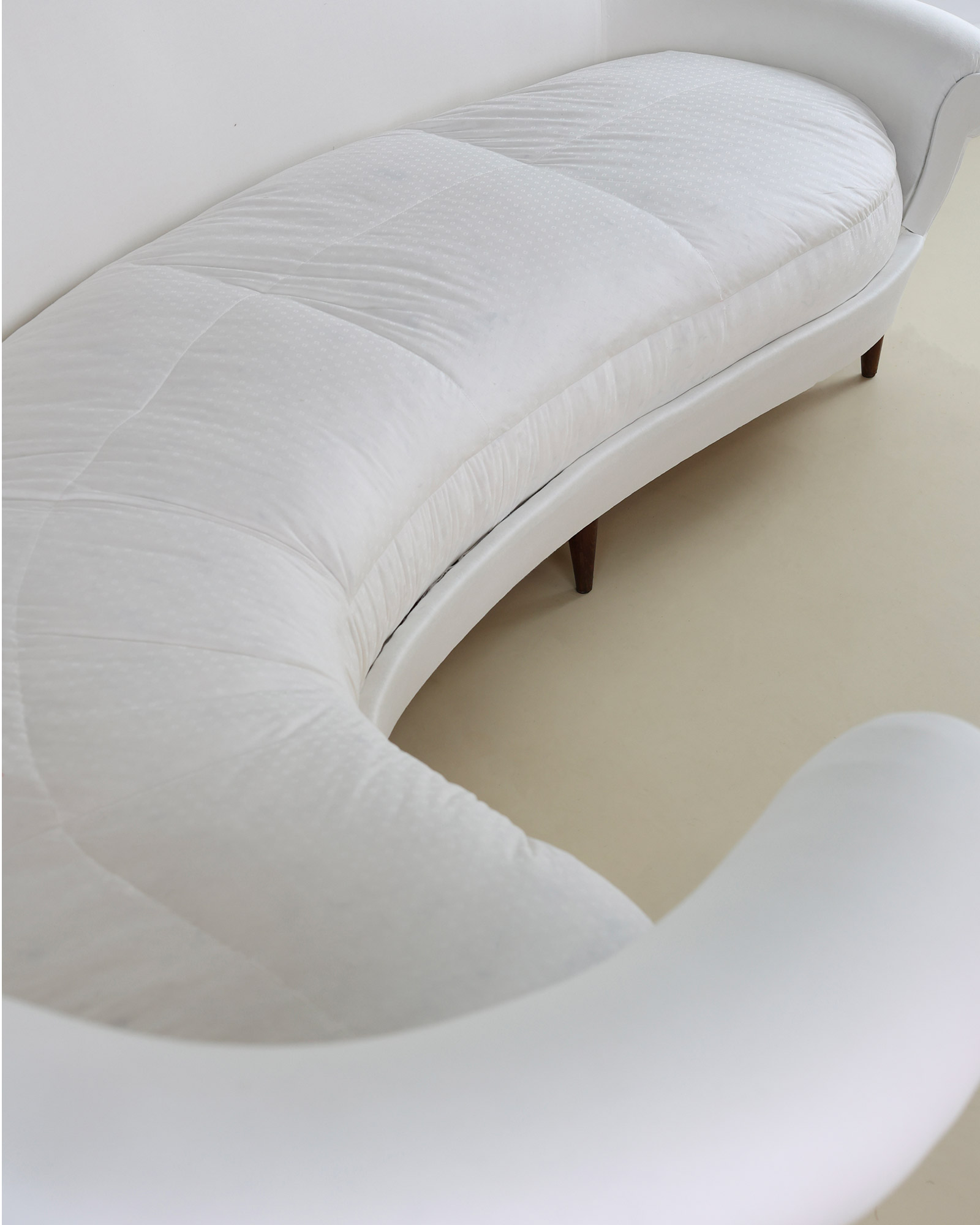 Munari curved sofa by Federico Munari - high-angle view showcasing the elegant curved silhouette and seat depth