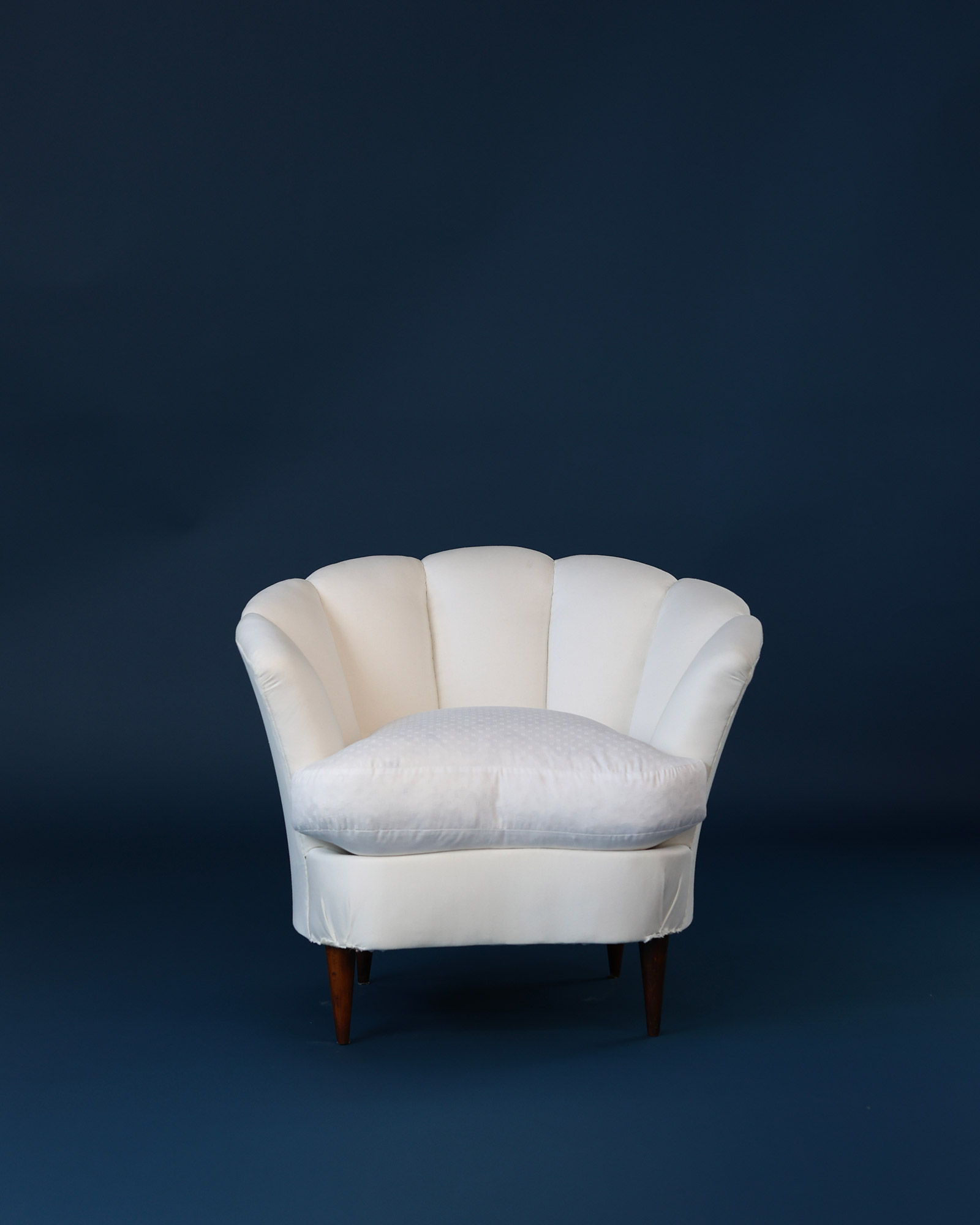 Pair of 1950s Italian armchairs by Gio Ponti - full front view with white upholstery on a blue background