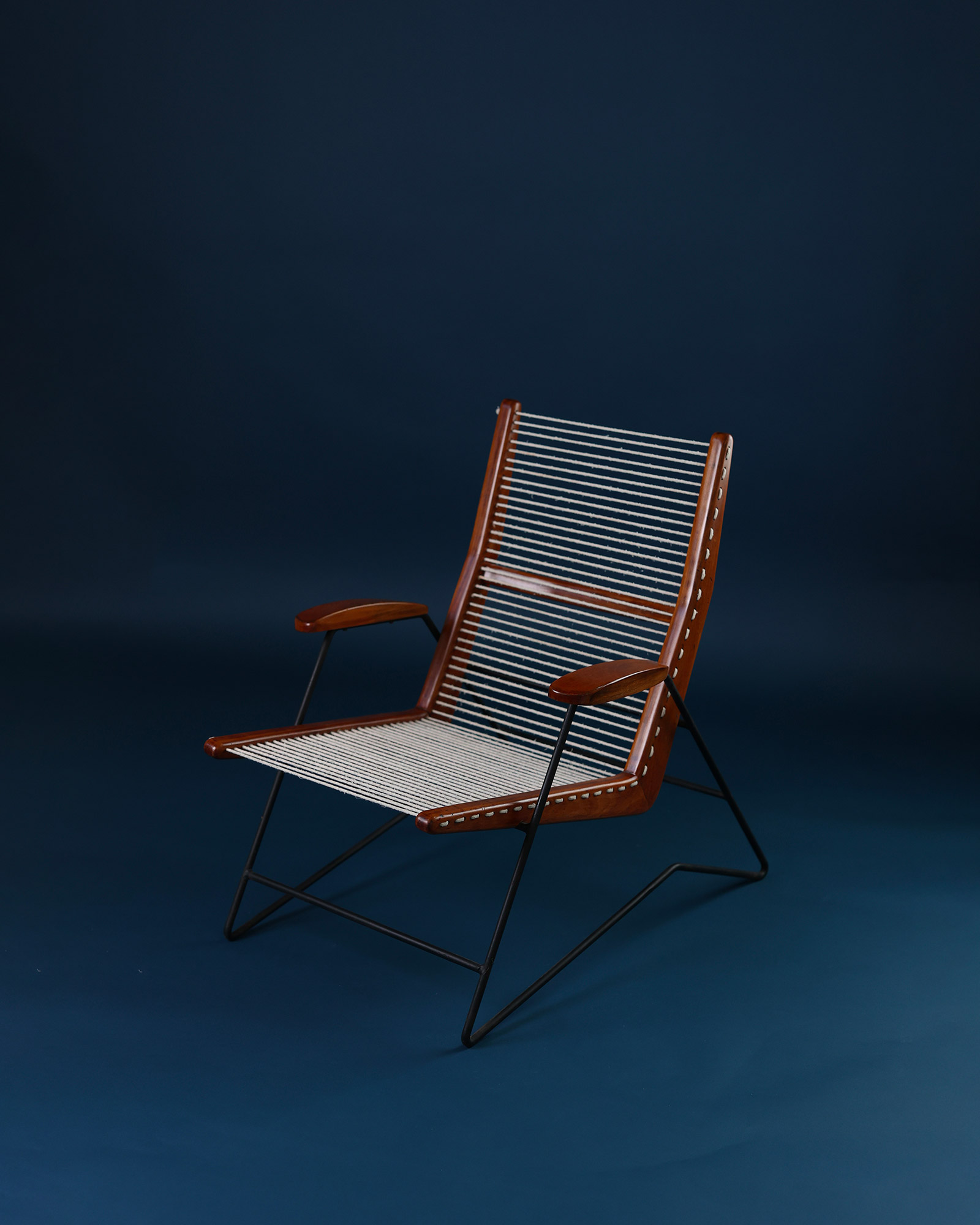 String armchair by Carlo Hauner - three-quarter front angle highlighting the wooden frame and metal legs