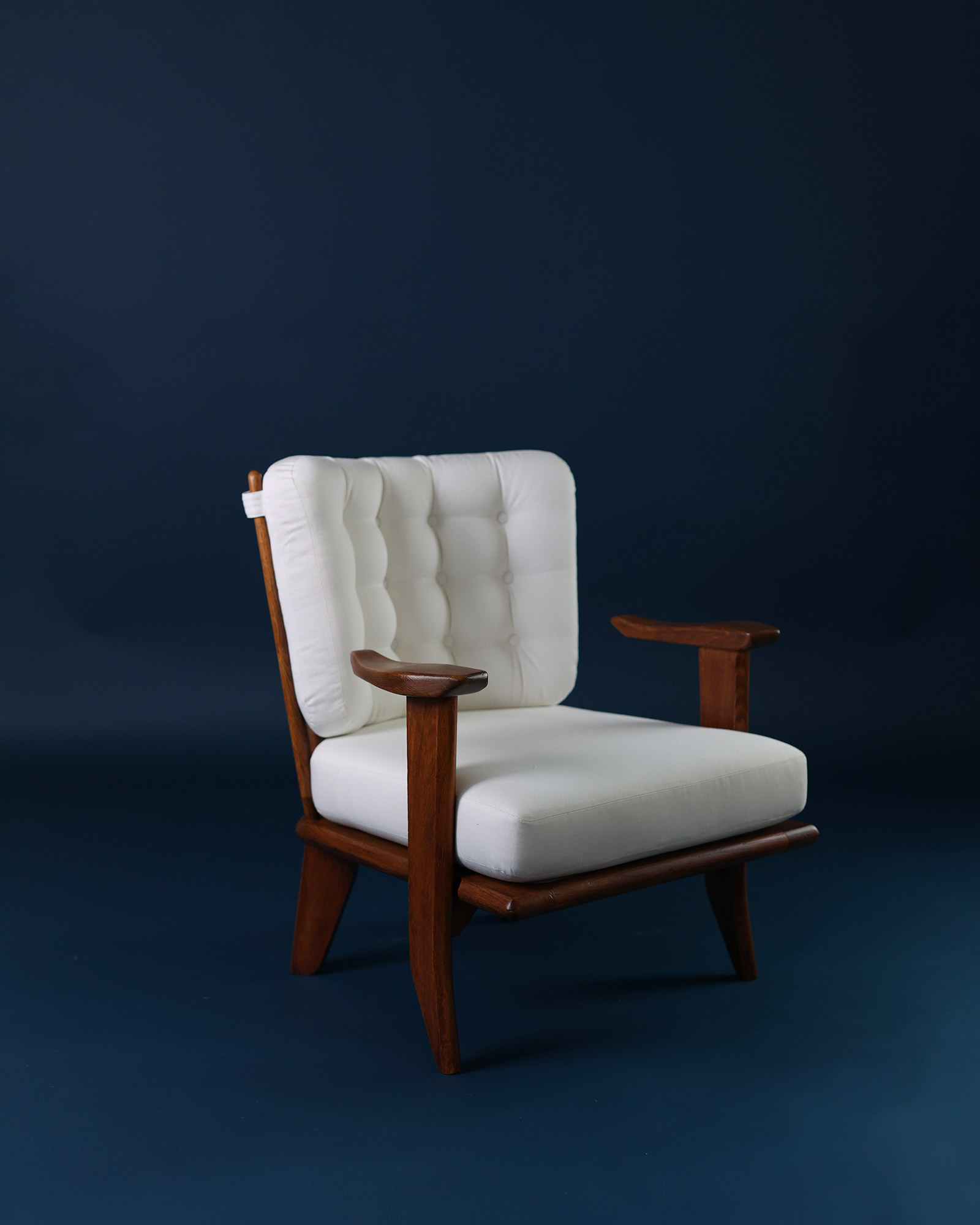 Catherine armchair by Guillerme et Chambron - three-quarter angle view showcasing the wooden armrests and seat depth