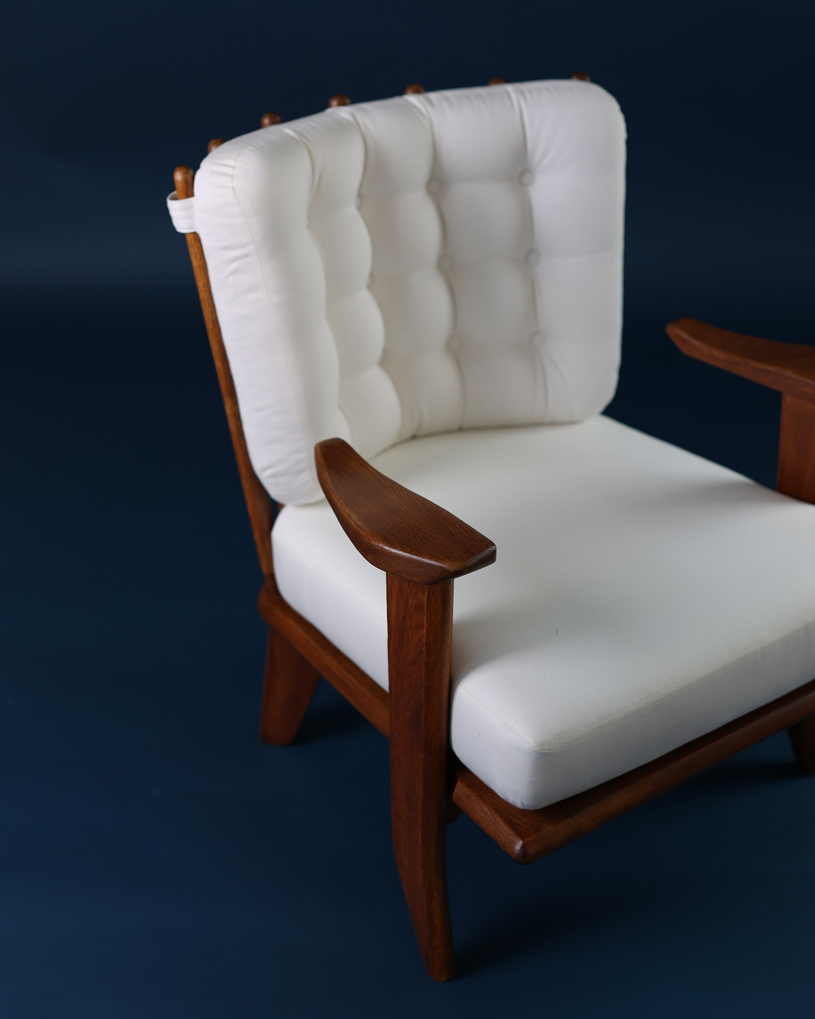 Catherine armchair by Guillerme et Chambron - high-angle close-up highlighting the tufted upholstery and wood joinery