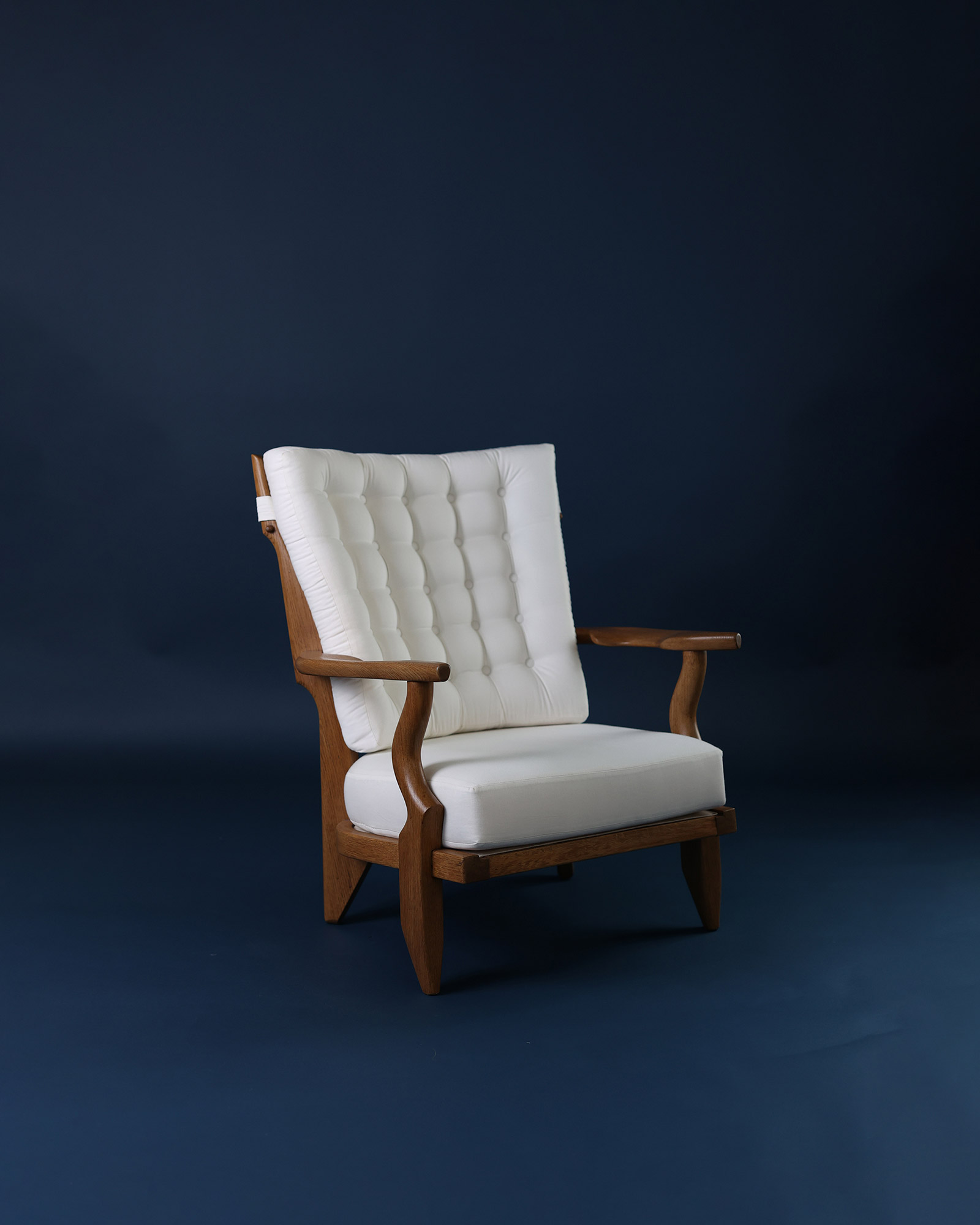 Petit Repos armchair by Guillerme et Chambron - three-quarter perspective highlighting the wooden armrests and seat profile
