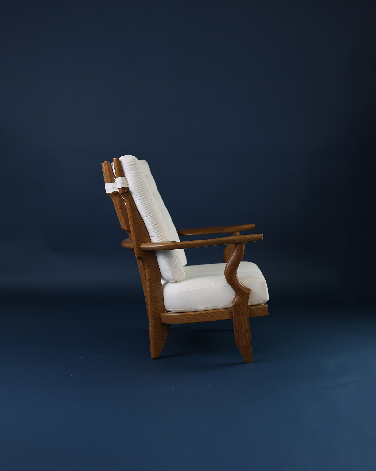 Petit Repos armchair by Guillerme et Chambron - side profile view showcasing the reclined wooden frame structure
