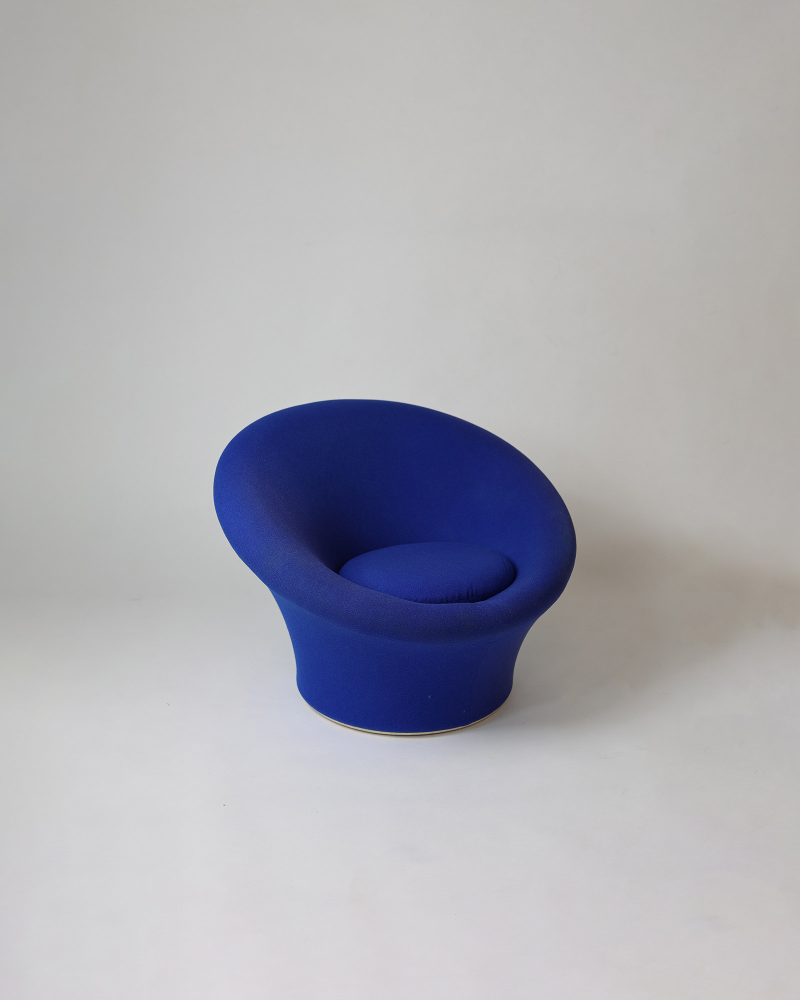 A direct front-on view of the unique, sculptural shape of a dark blue upholstered Pierre Paulin Mushroom lounge chair.