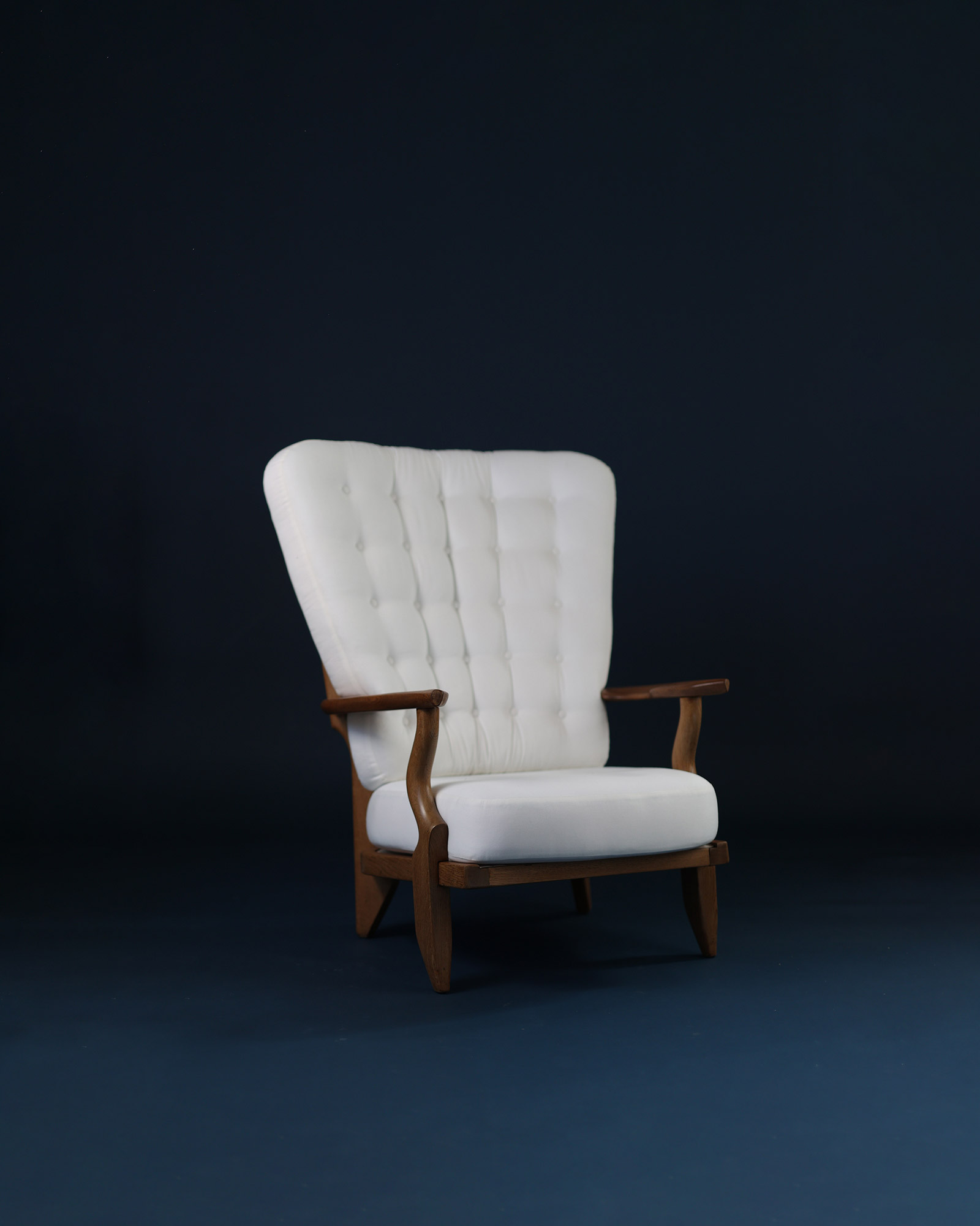 Grand Repos armchair by Guillerme et Chambron - three-quarter perspective highlighting the wooden armrests and high backrest