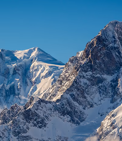 Montagnes enneigées sous un ciel bleu clair sans nuages, La Ferme des Drus, Chamonix-Mont-Blanc, France.
