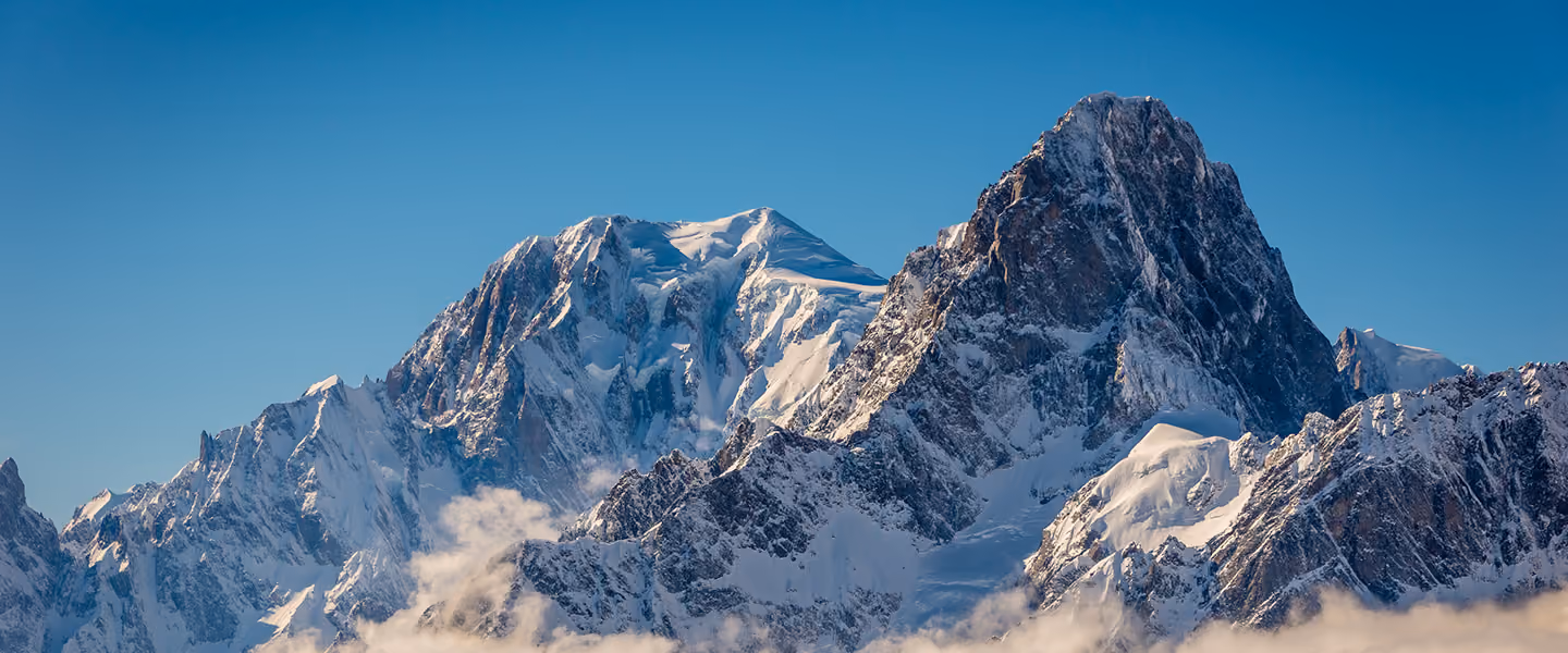 Chaîne de montagnes enneigées sous un ciel bleu clair, La Ferme des Drus, Chamonix-Mont-Blanc, France.