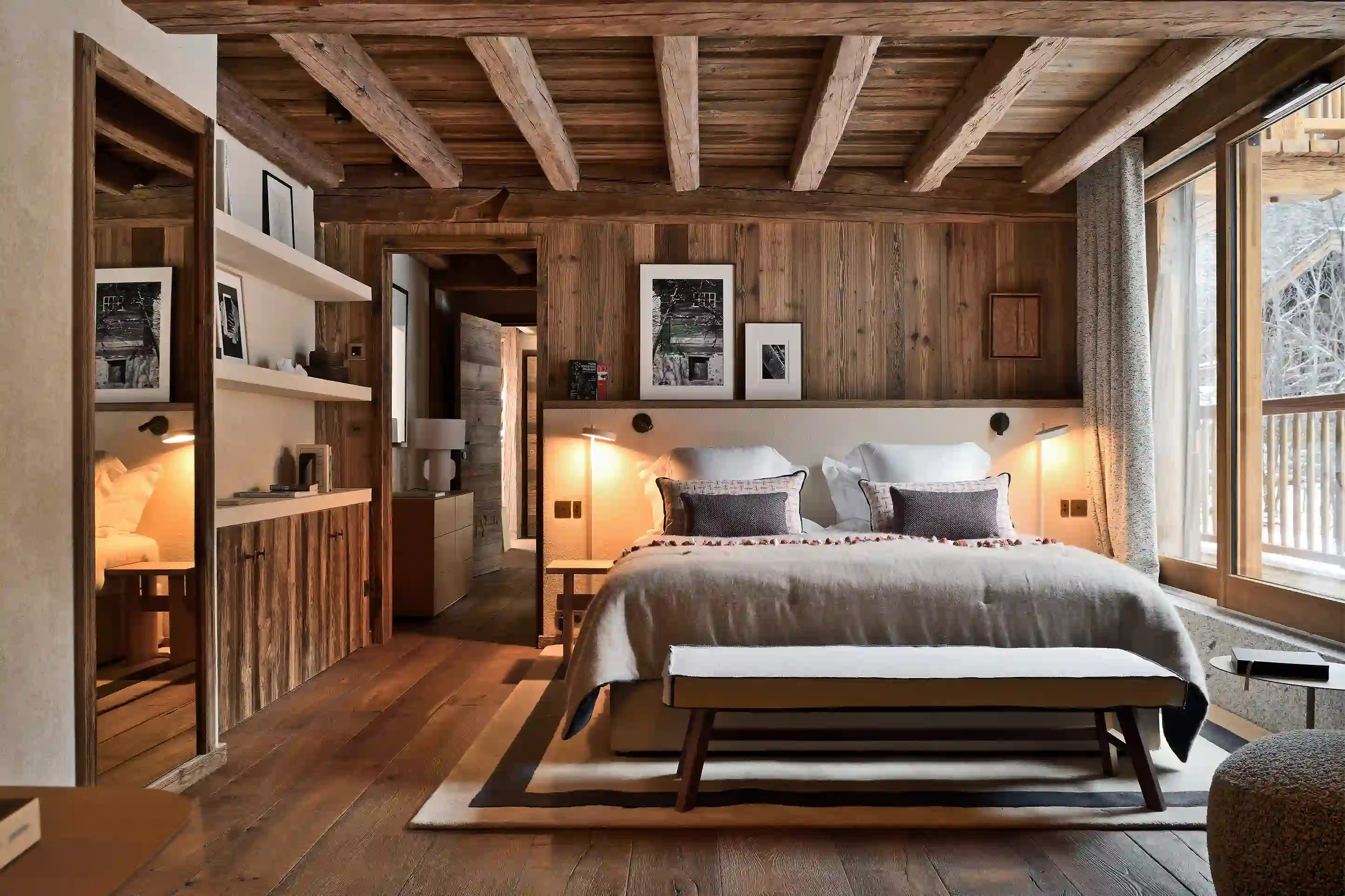 Chambre rustique avec lit double, murs et plafond en bois, grandes fenêtres et ambiance chaleureuse, La Ferme des Drus, Chamonix-Mont-Blanc, France.