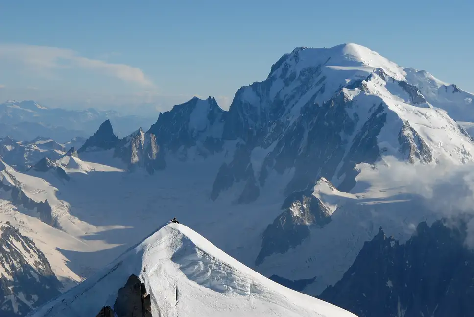 Vue de montagnes enneigées, avec un sommet en pointe et un ciel bleu clair, La Ferme des Drus, Chamonix-Mont-Blanc, France.