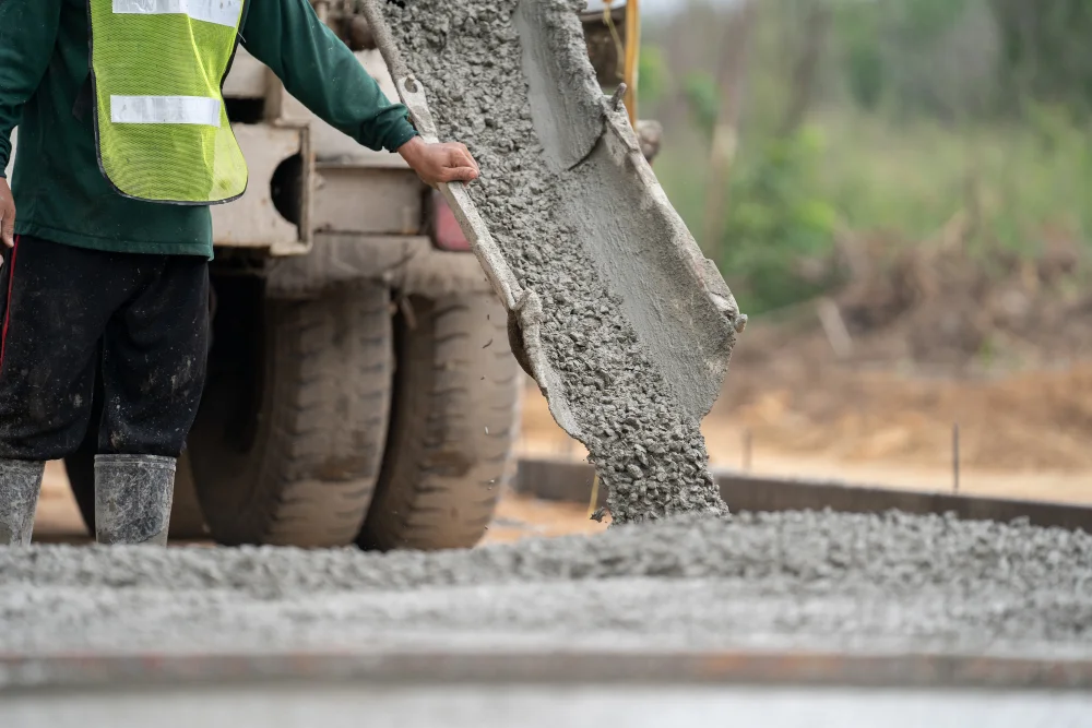 Scarico del calcestruzzo dallo scivolo dell'autobetoniera in cantiere