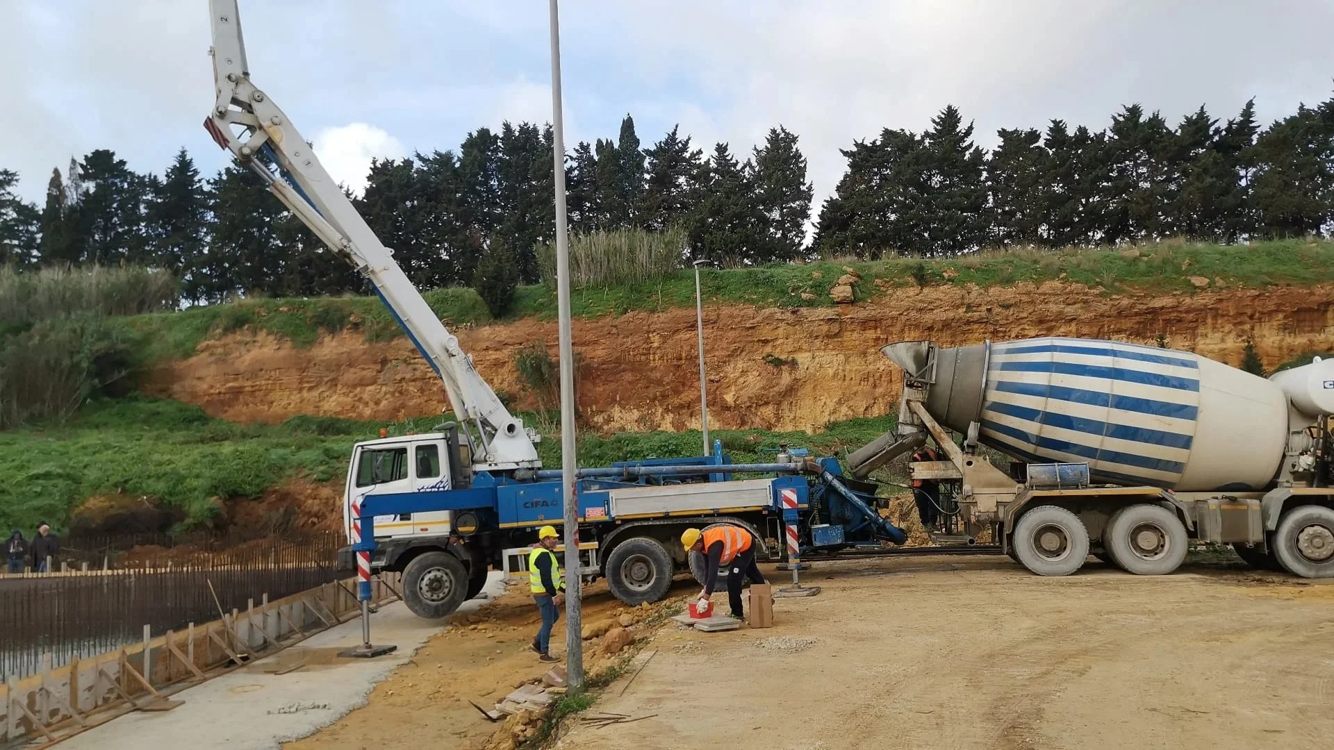 Getto di calcestruzzo con pompa in cantiere