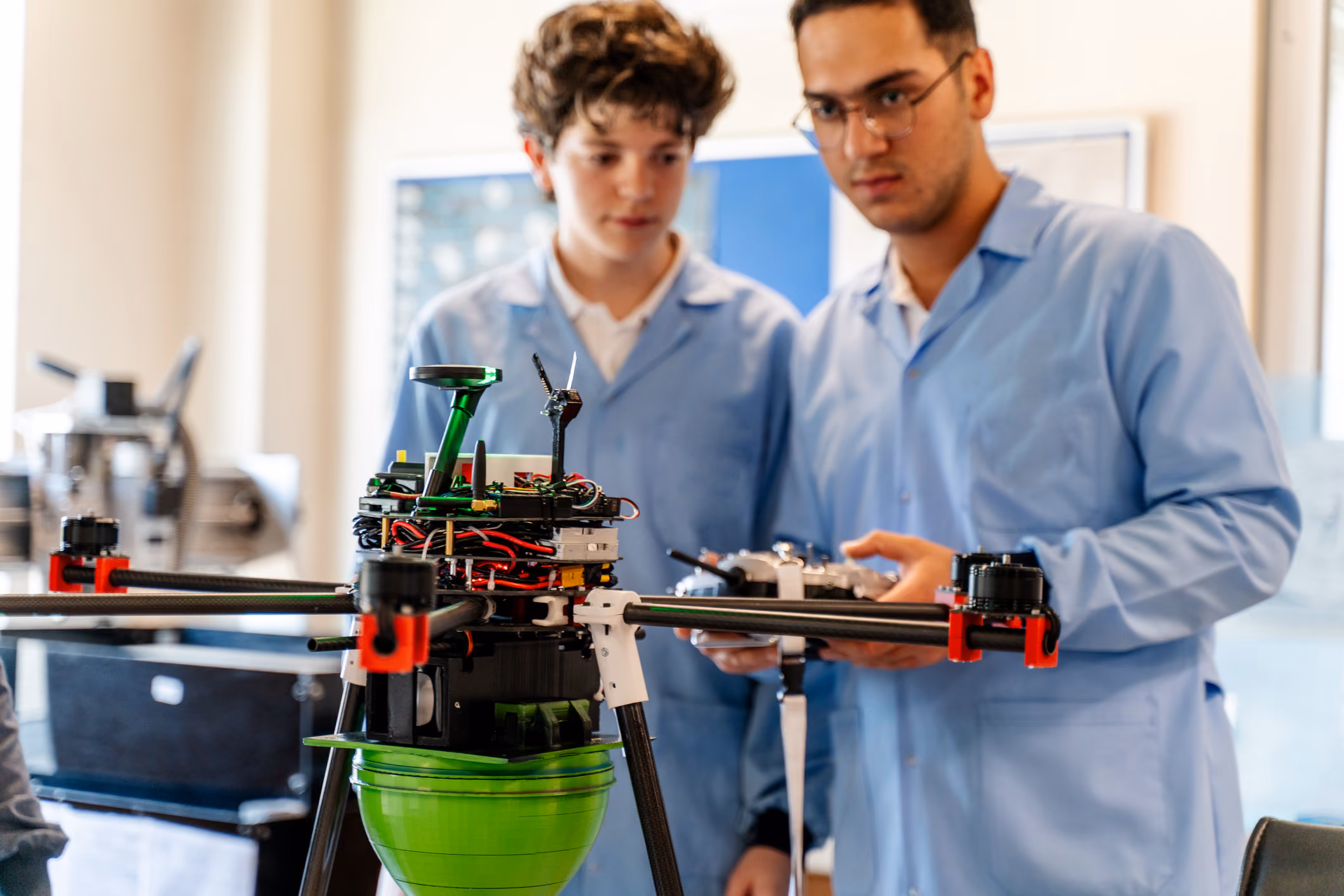Deux lycéens observent un drone qu'ils ont conçu en atelier