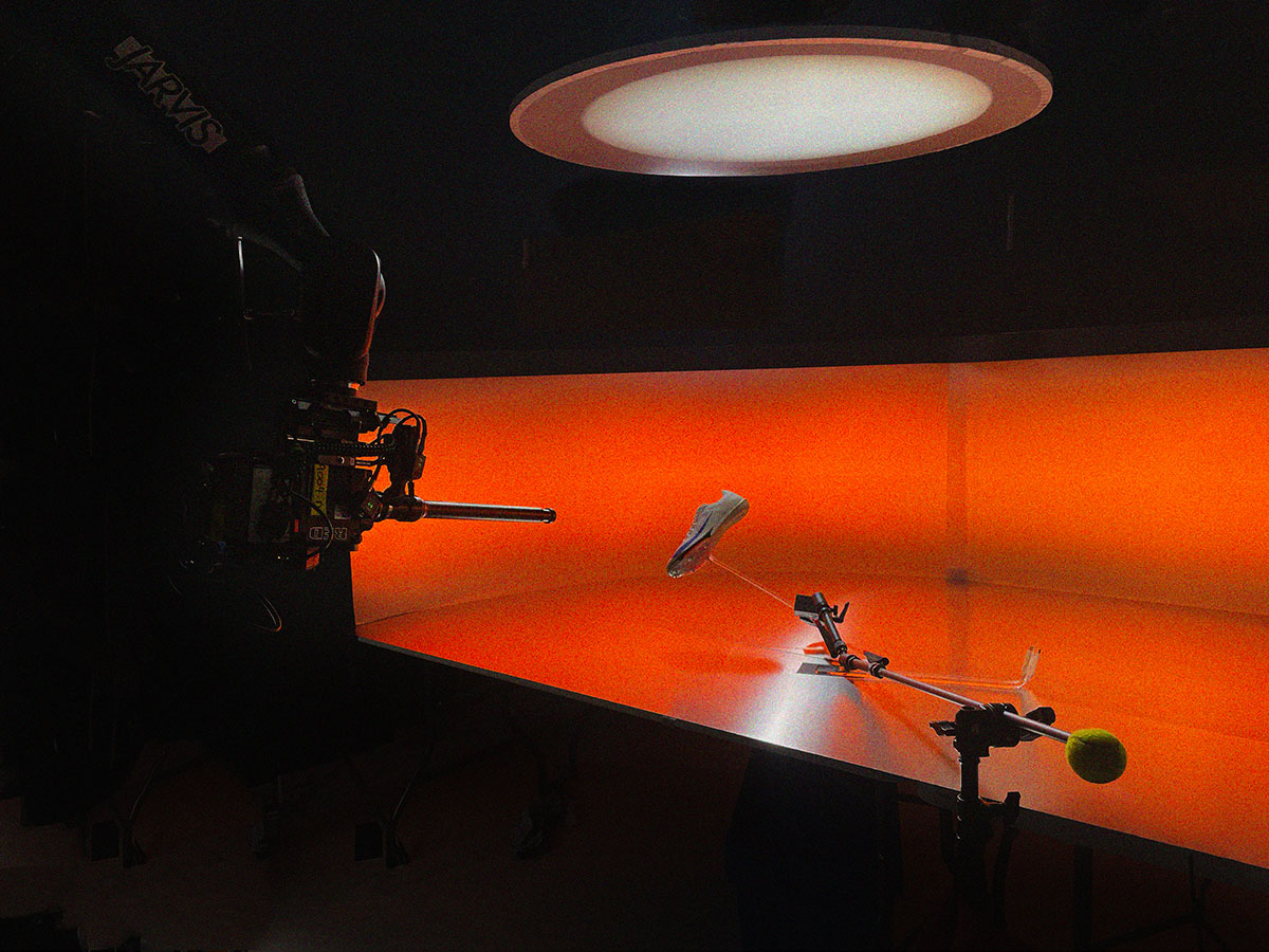 Motion control arm filming a small object on an orange curved cyclorama