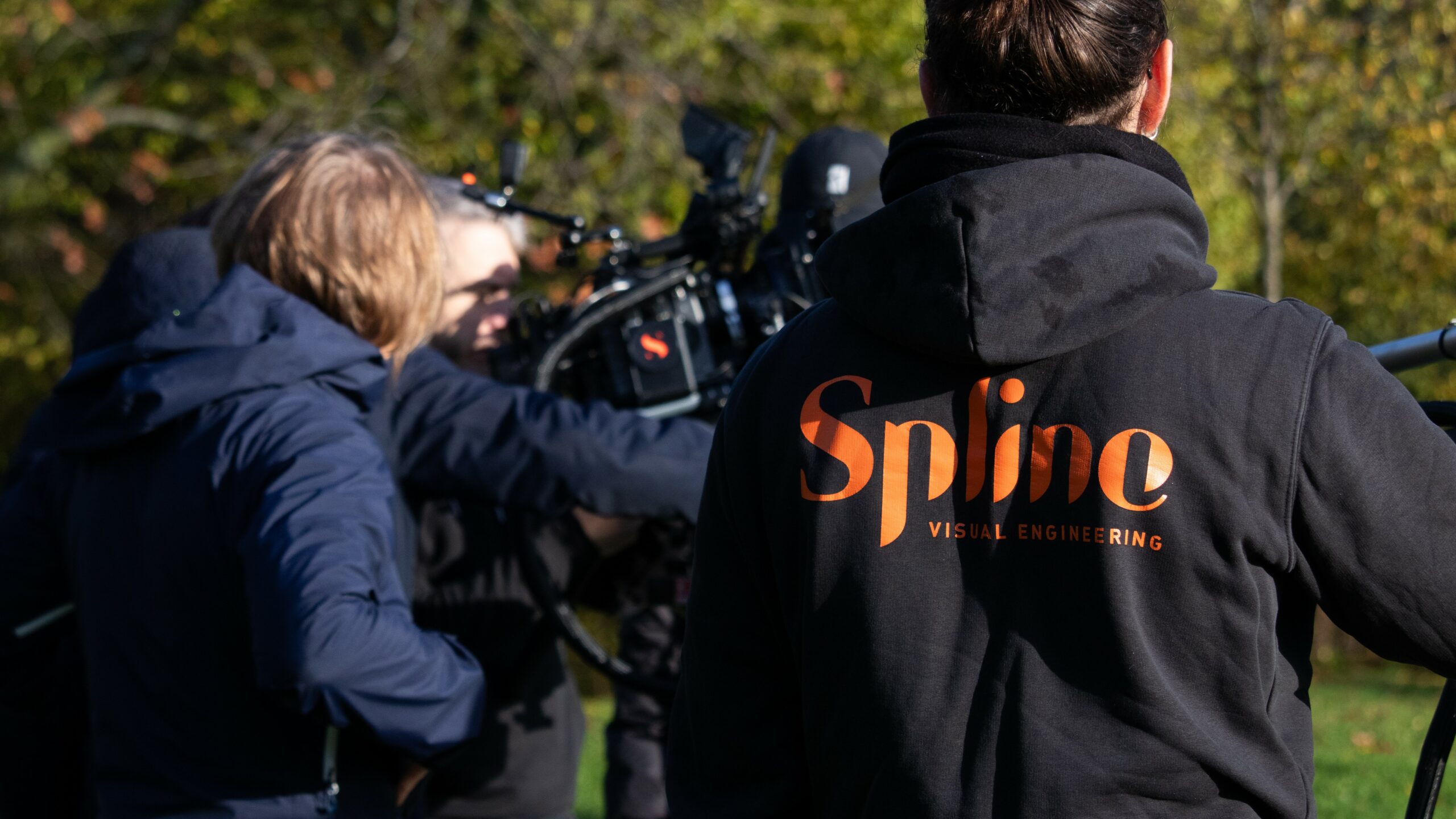 Two Spline technicians operating a cinema camera on a forest location shoot