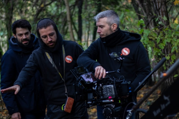 Two Spline technicians operating a cinema camera on a forest location shoot