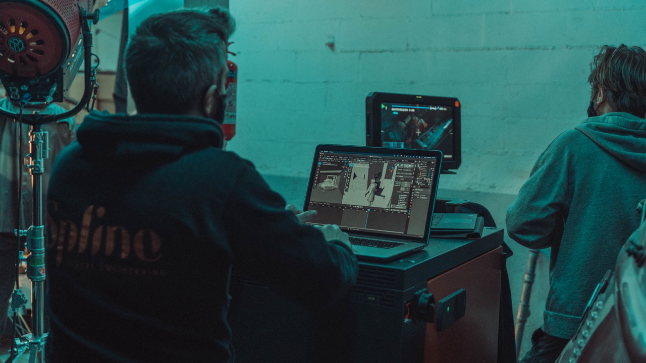Motion control operator and assistant programming a robot rig beside the camera team