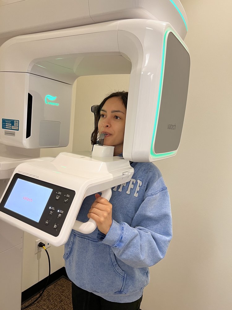 Patient receiving a digital dental scan with a modern panoramic imaging machine during a diagnostic dental appointment