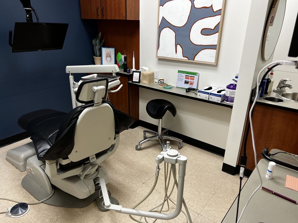 Modern dental treatment room with a comfortable patient chair advanced dental equipment wood cabinetry and a clean welcoming clinical environment