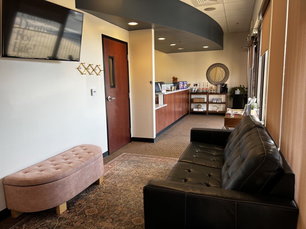 Modern dental office reception area with comfortable seating front desk large windows and a warm welcoming environment for dental patients
